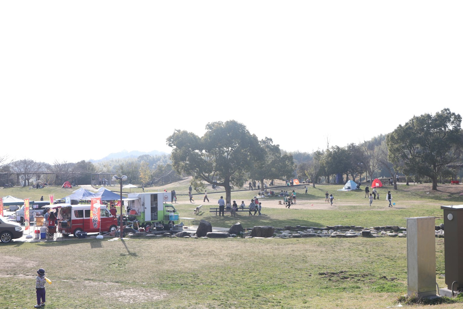 Eine weite Parkszene mit spielenden Menschen und Food-Trucks