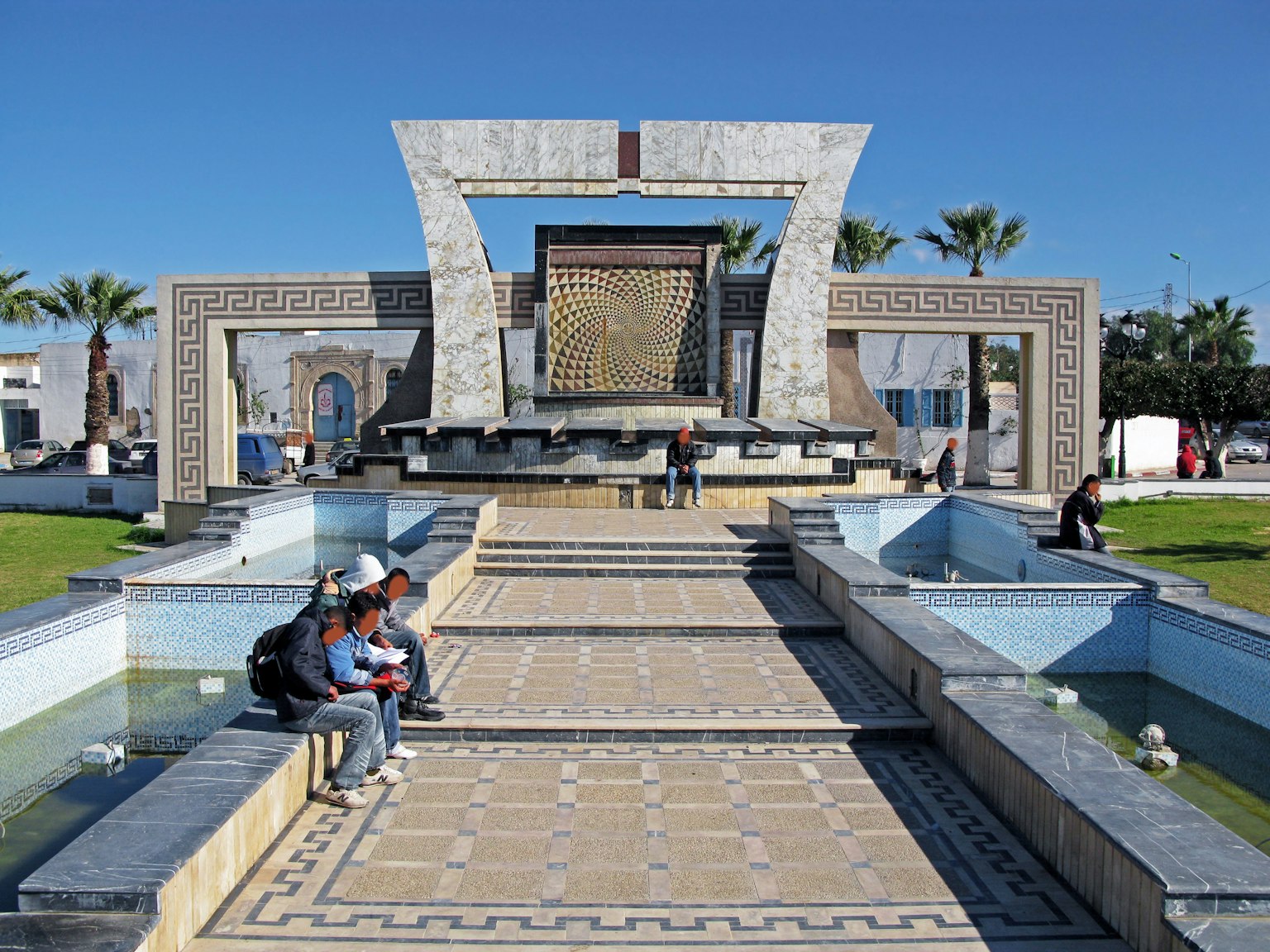 Fontana moderna e piazza in mosaico in Marocco con persone sedute
