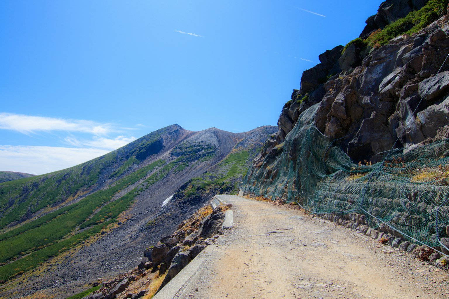 藍天下的風景如畫的山路和岩石懸崖
