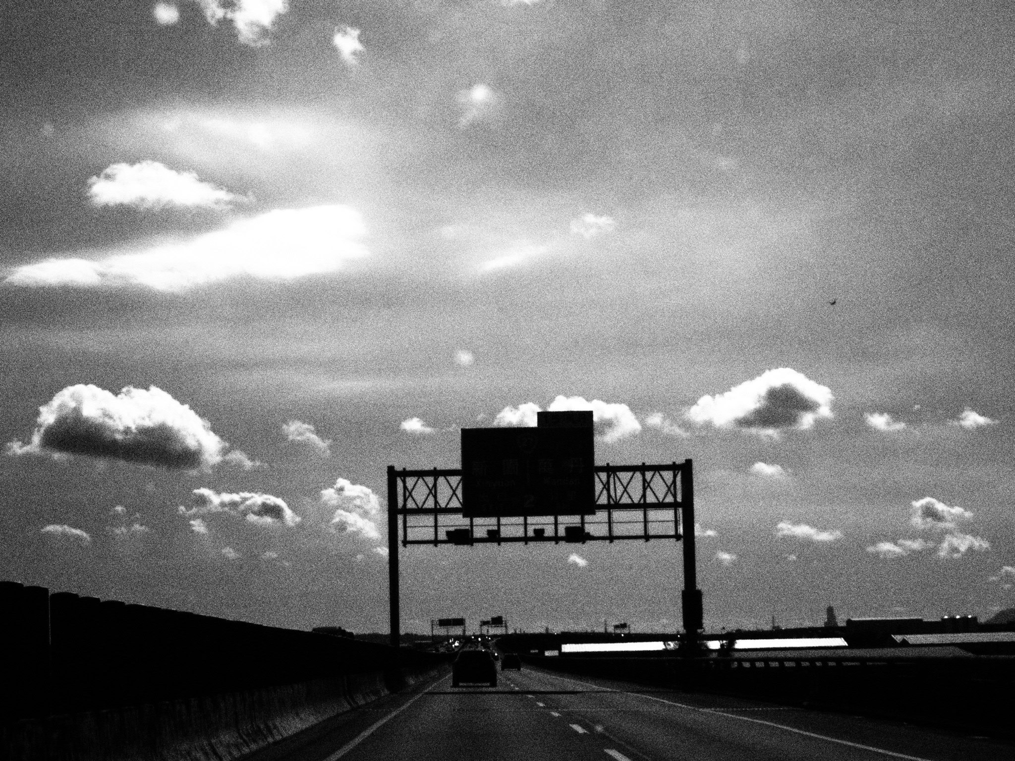 A long straight road landscape under a cloudy sky