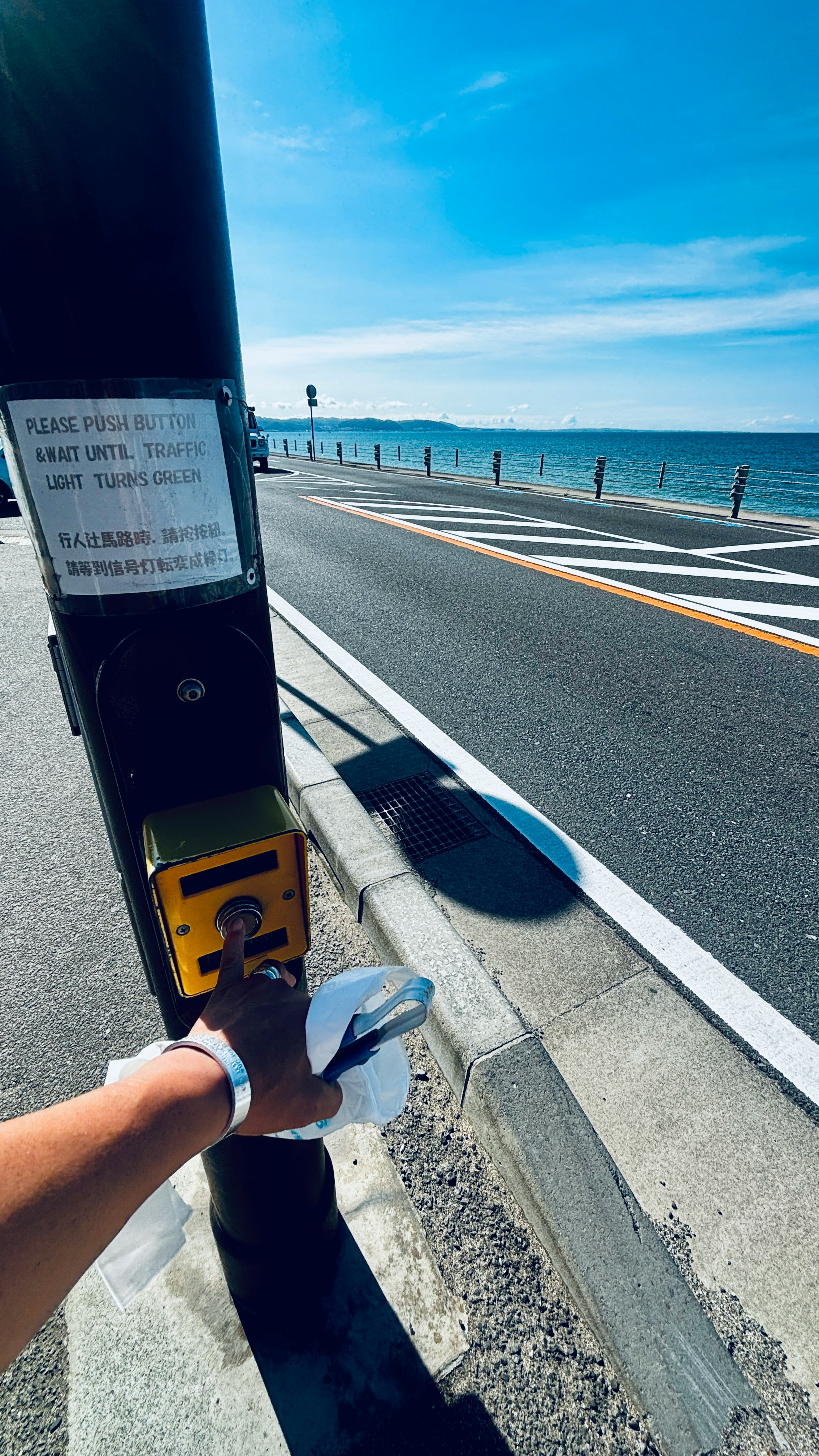 海辺の遊歩道で手を振る人のある風景