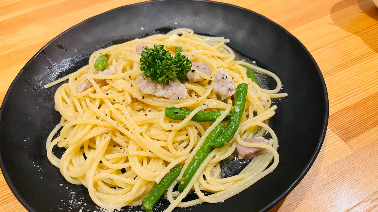 黑色盘子上的奶油意大利面和绿色芦笋