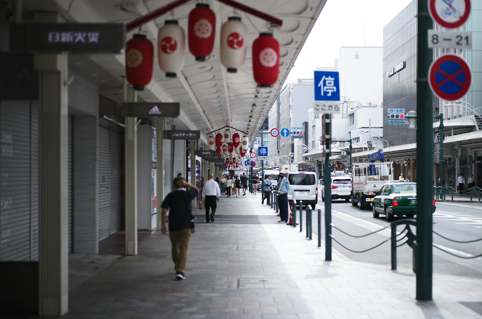 Street view with people walking and red lanterns hanging