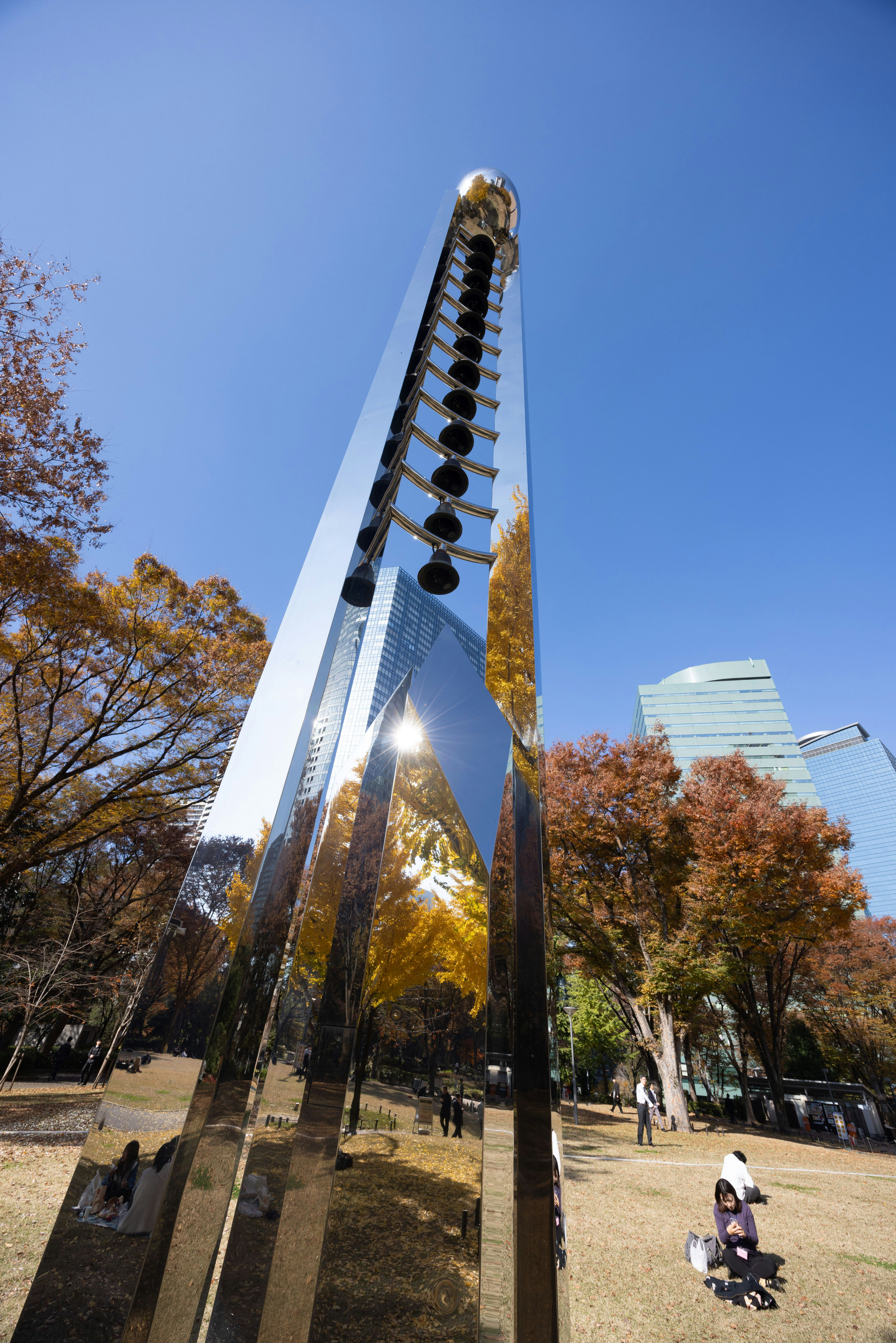 青空の下でそびえ立つ近未来的な塔と広場