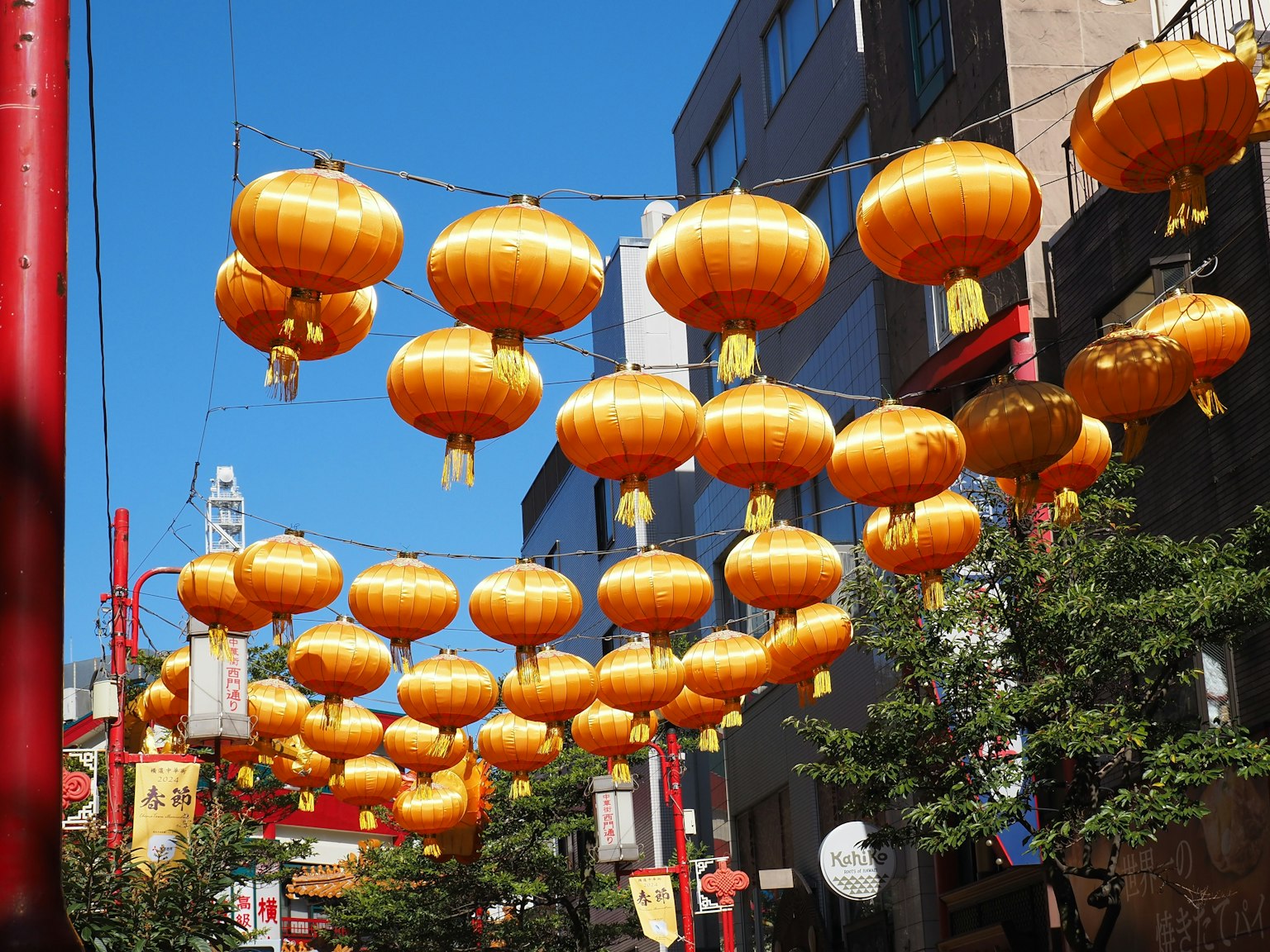 Con phố trang trí bằng đèn lồng vàng treo dưới bầu trời xanh