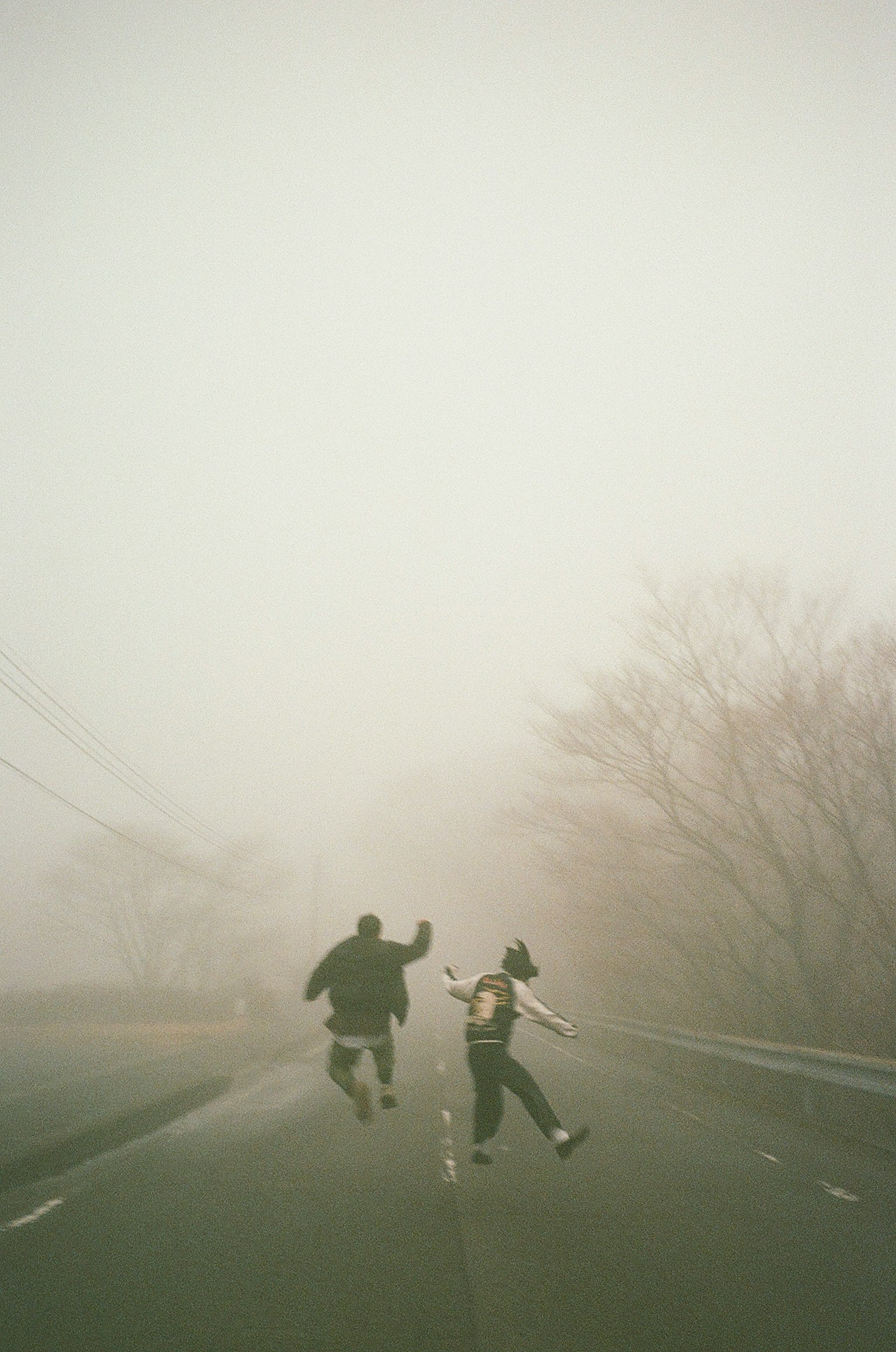 Siluetas de dos niños corriendo en la niebla