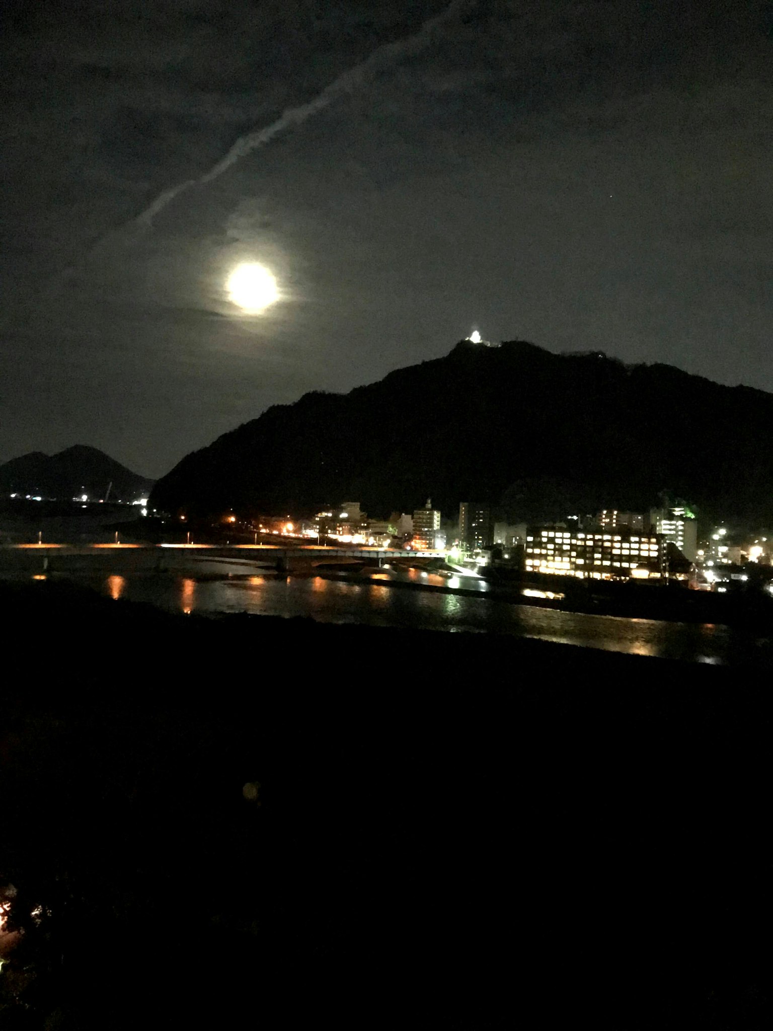 Night view featuring a bright moon and mountain silhouette