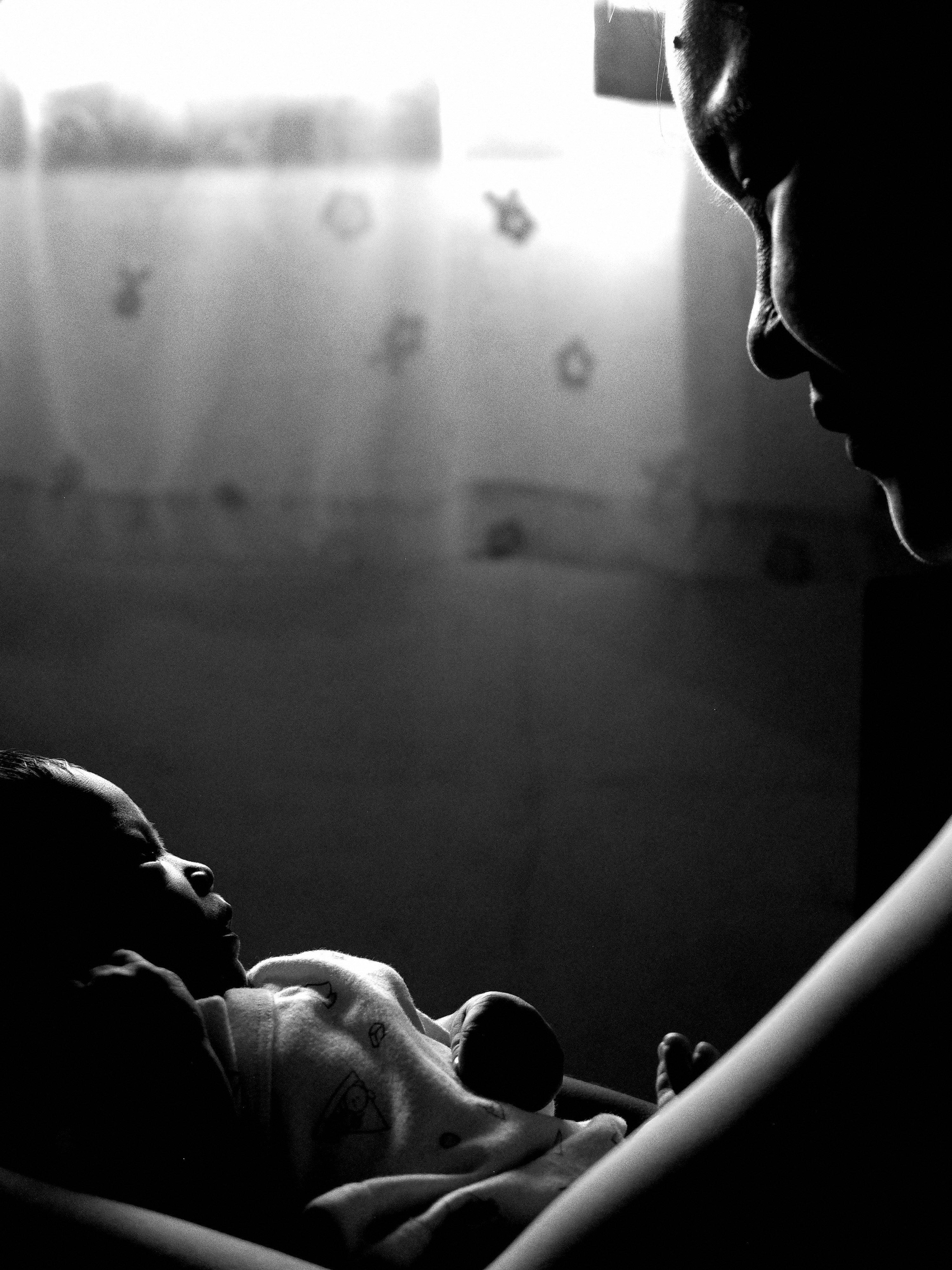newborn baby sleeping in a mother’s arms, side profile