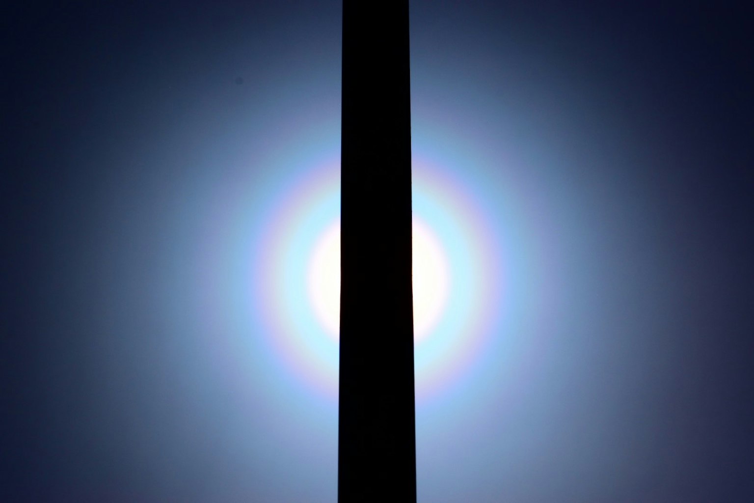 Silhouette eines schwarzen Pfeilers gegen ein helles Licht