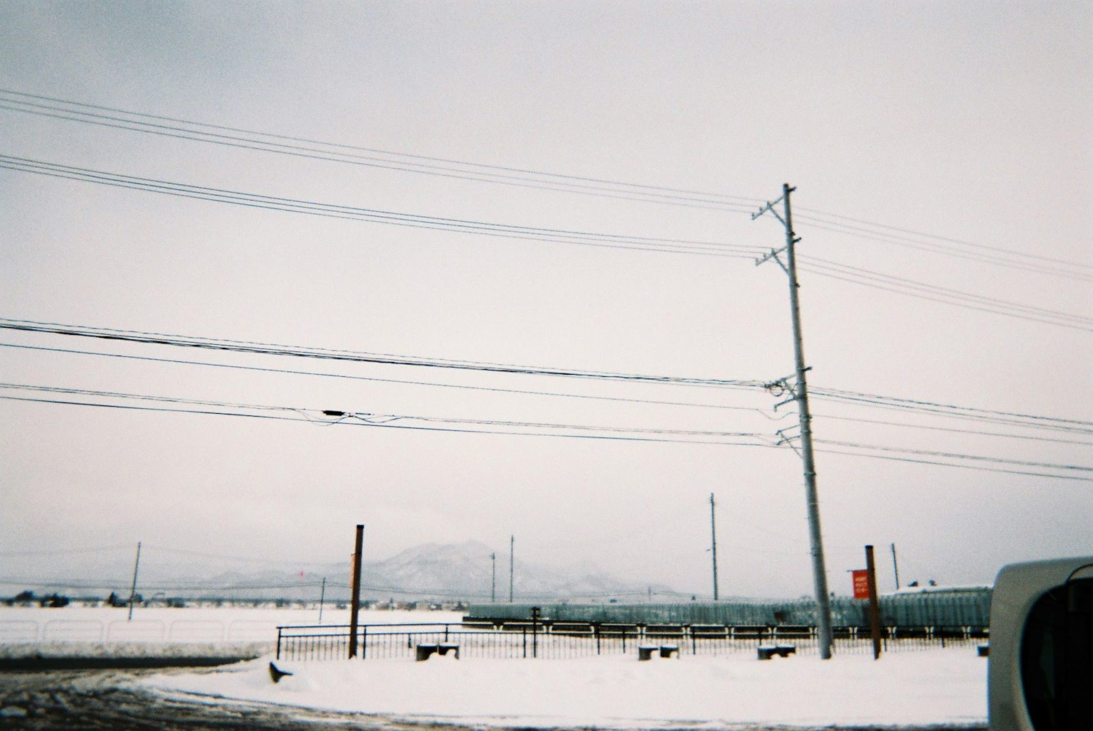 Snow-covered landscape with power poles and a serene atmosphere