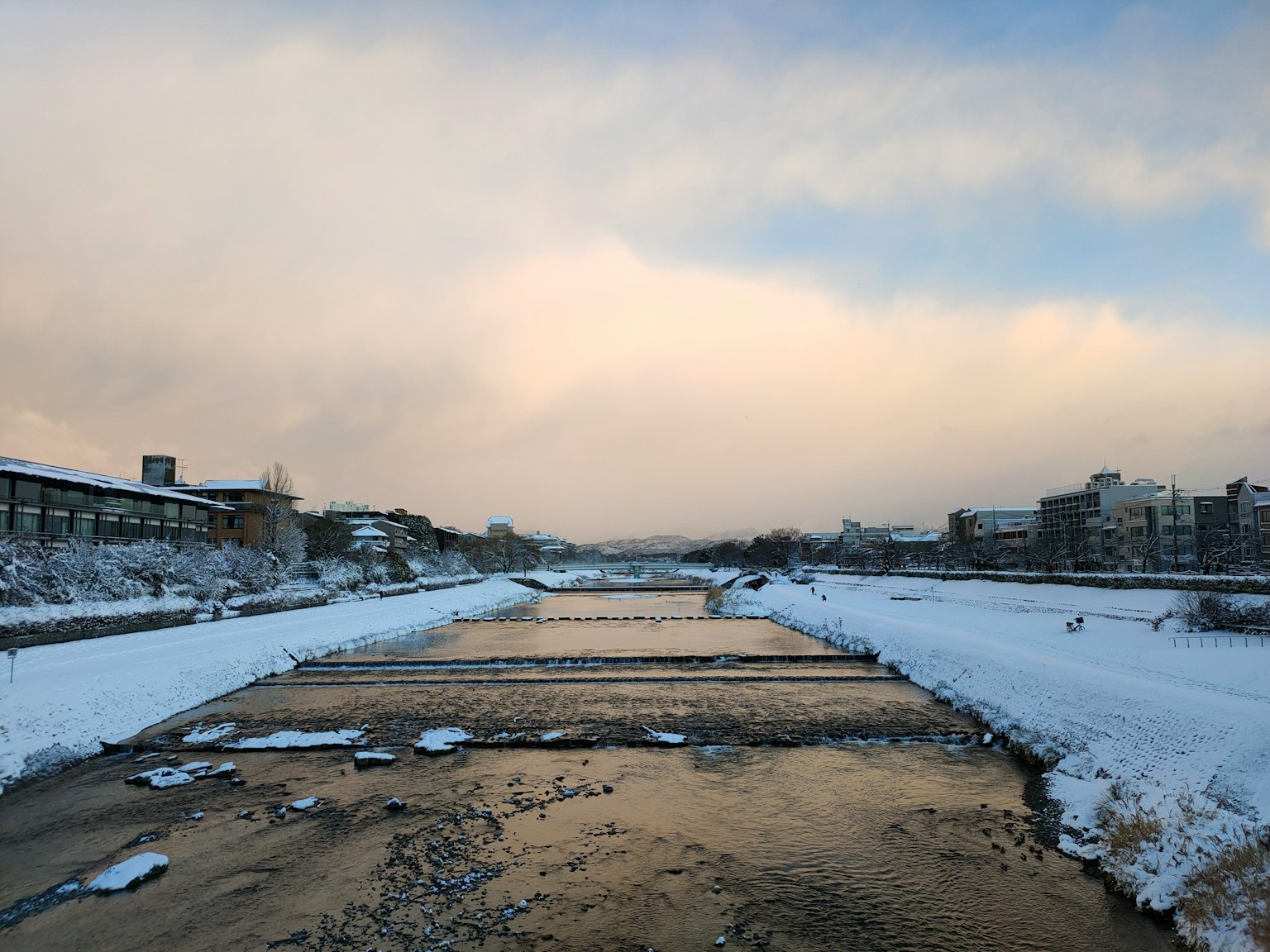 Schneebedeckter Fluss mit winterlichem Himmel