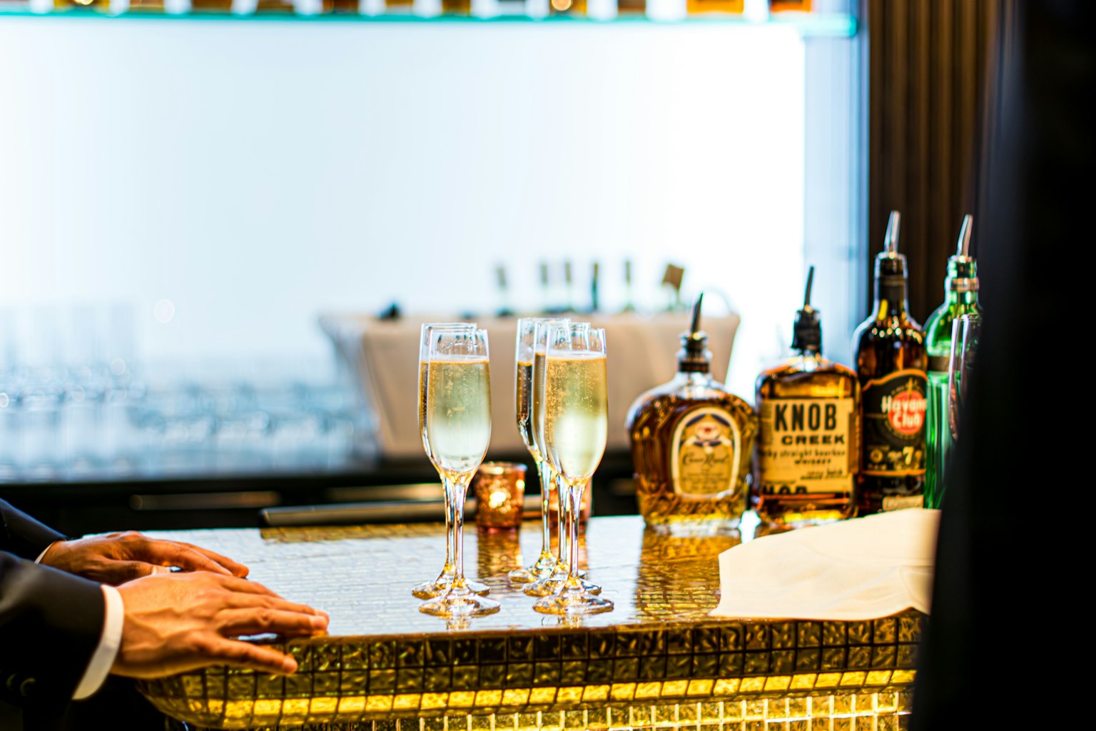 Comptoir de bar élégant avec des flûtes de champagne et des bouteilles de whiskey