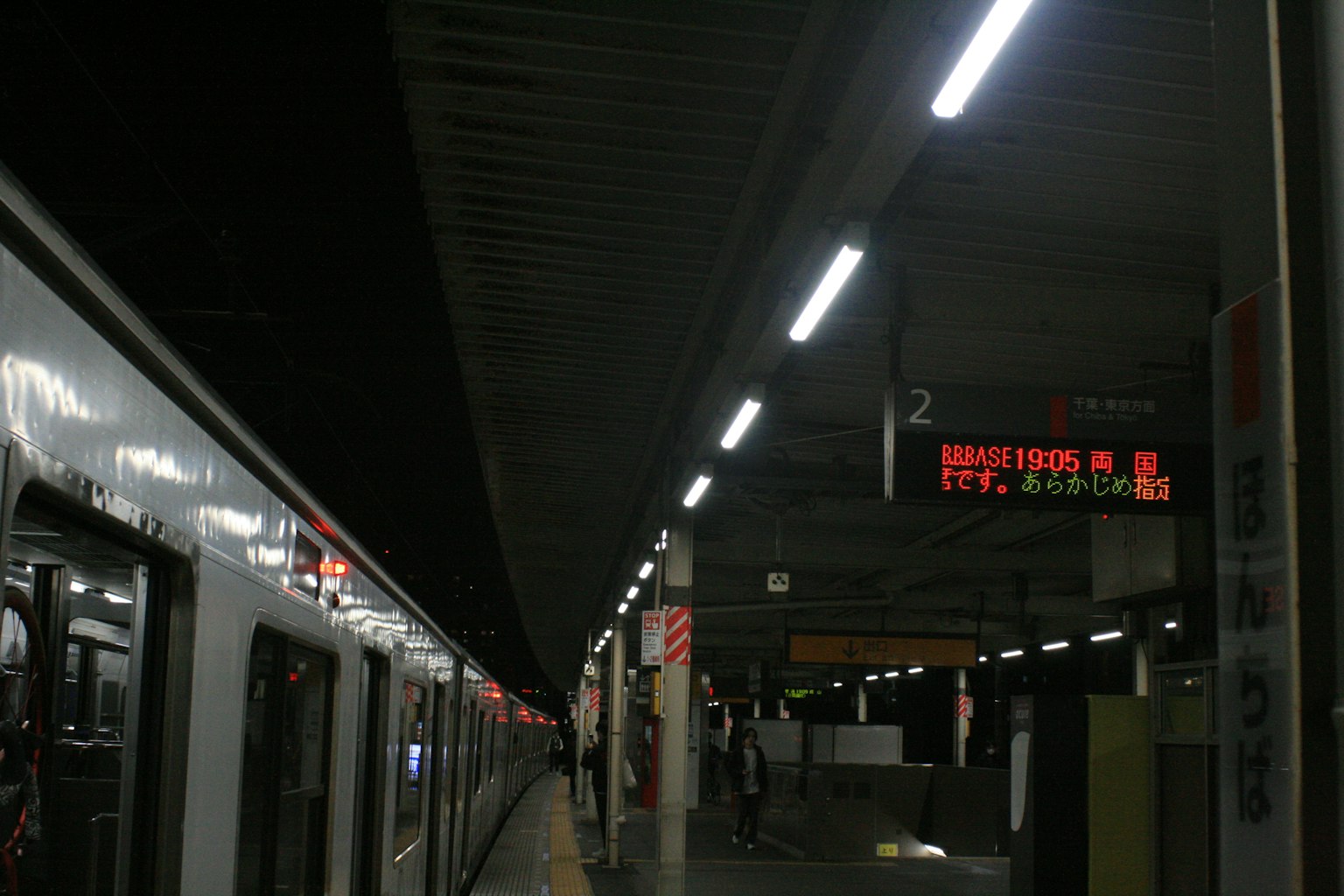 ภาพของรถไฟที่สถานี มีแสงสว่างและป้ายแสดงจุดหมายถัดไป