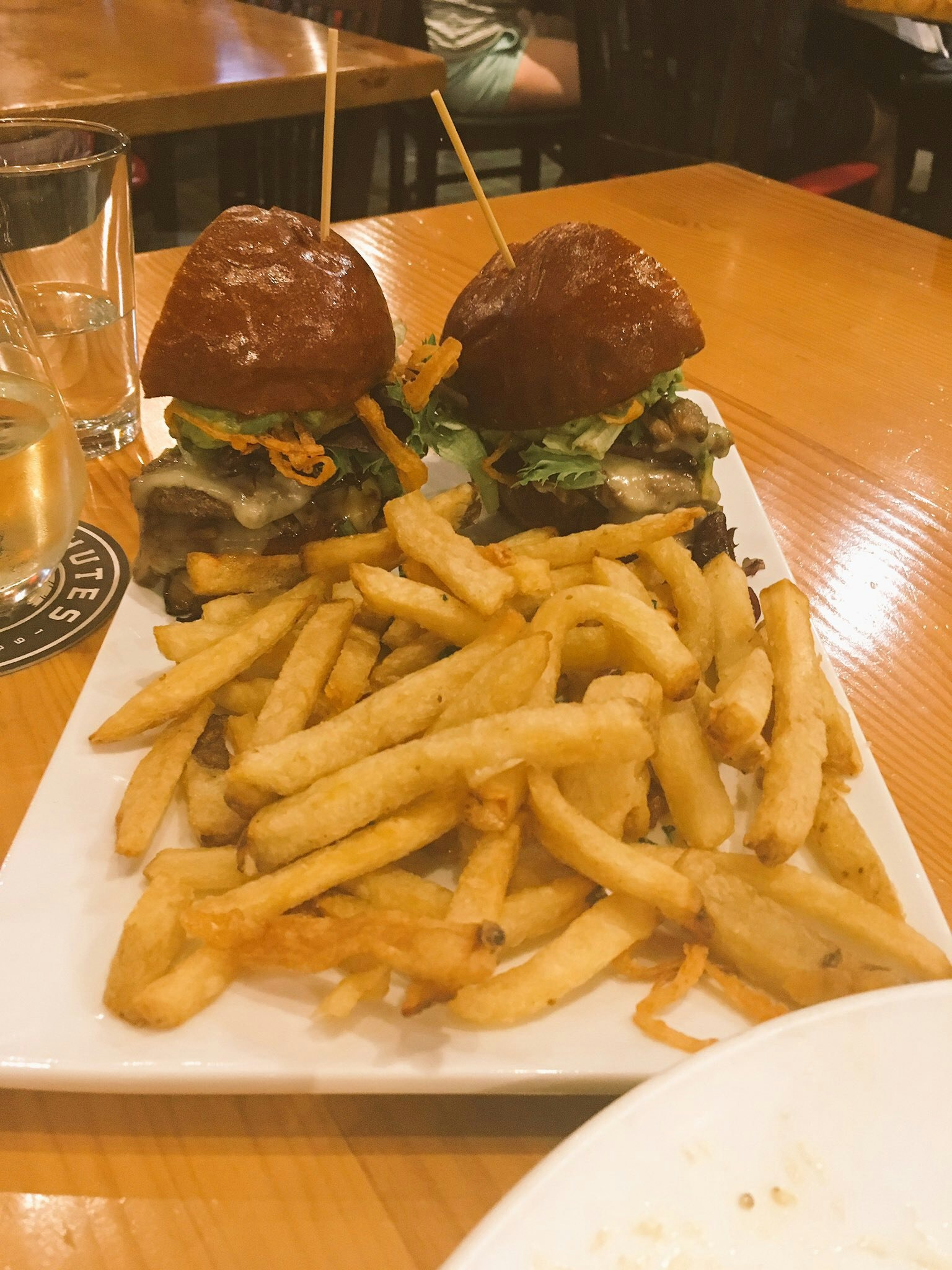 Un plato con dos hamburguesas y papas fritas