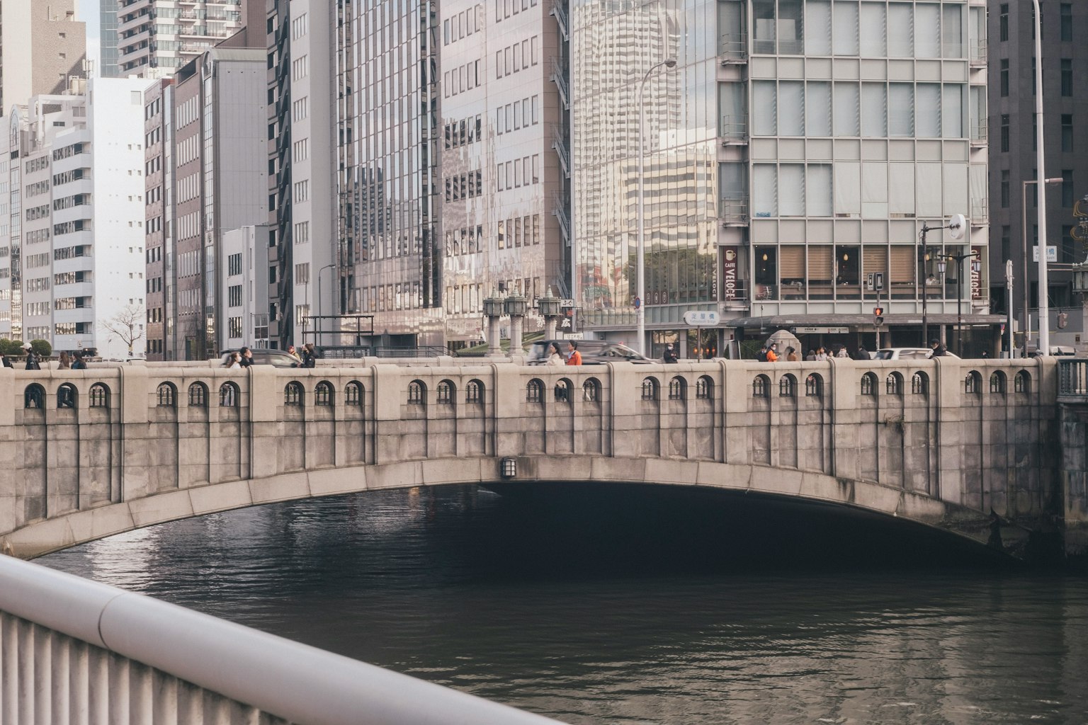 Eine schöne Bogenbrücke umgeben von modernen Gebäuden und einem Blick auf den Fluss