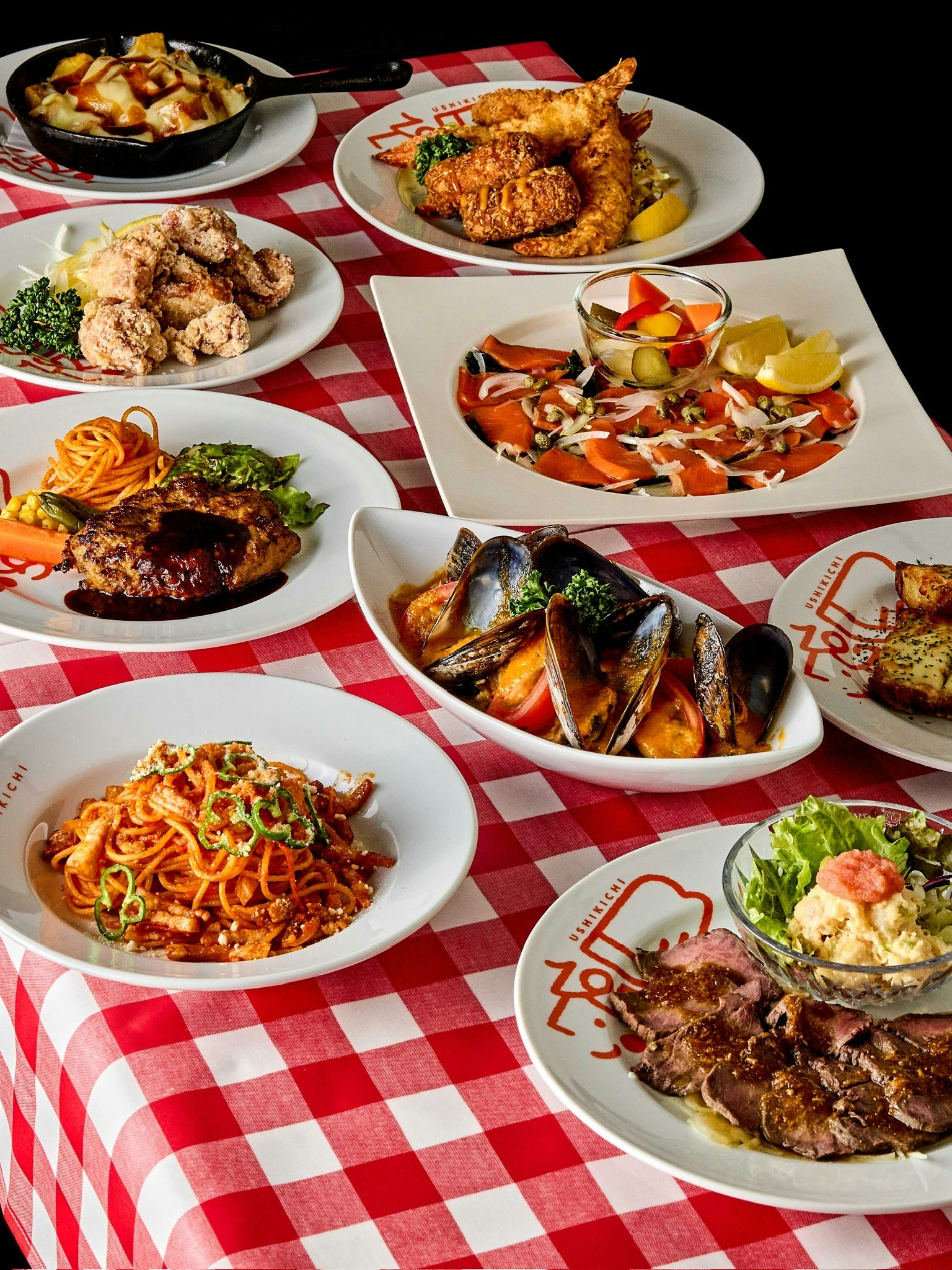 A variety of delicious dishes arranged on a red checkered tablecloth