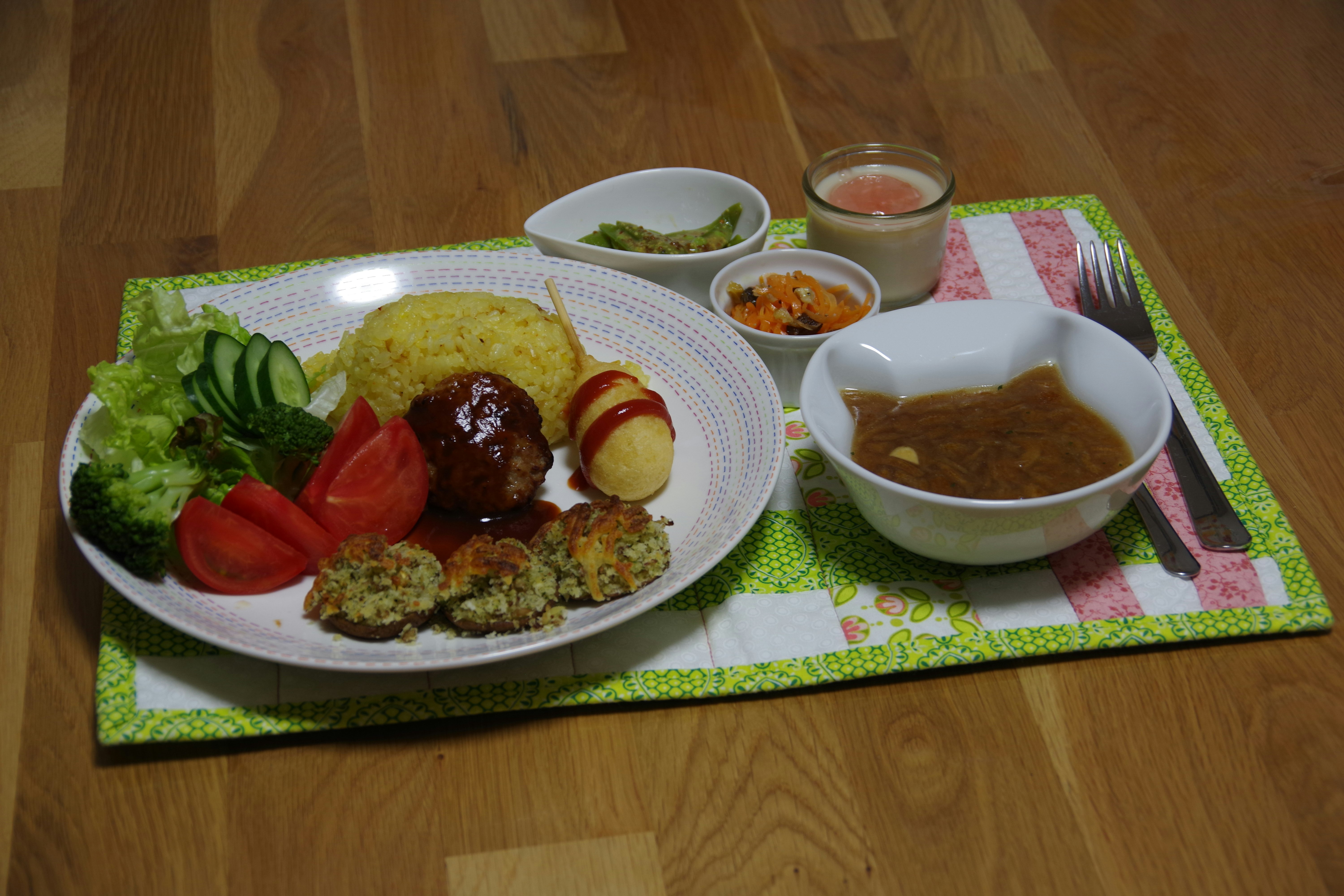 A delicious Japanese-style meal plate featuring meatballs rice salad and soup