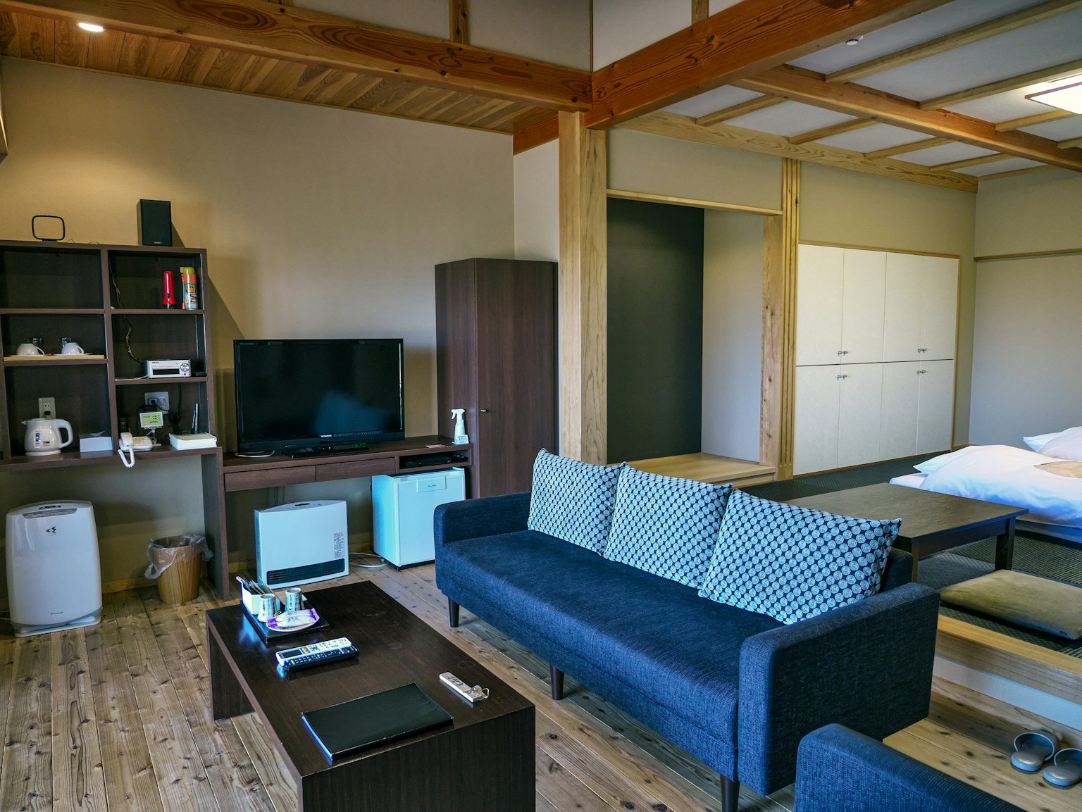 Sala de estar moderna de estilo japonés con muebles simples y techo de madera clara