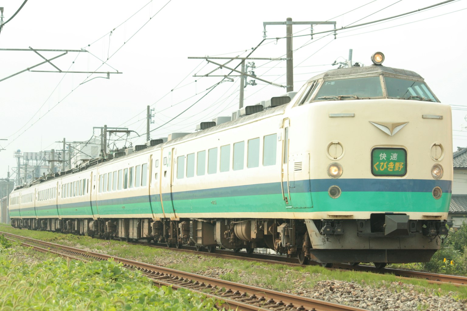 Kereta Jepang berwarna biru dan putih melaju di rel