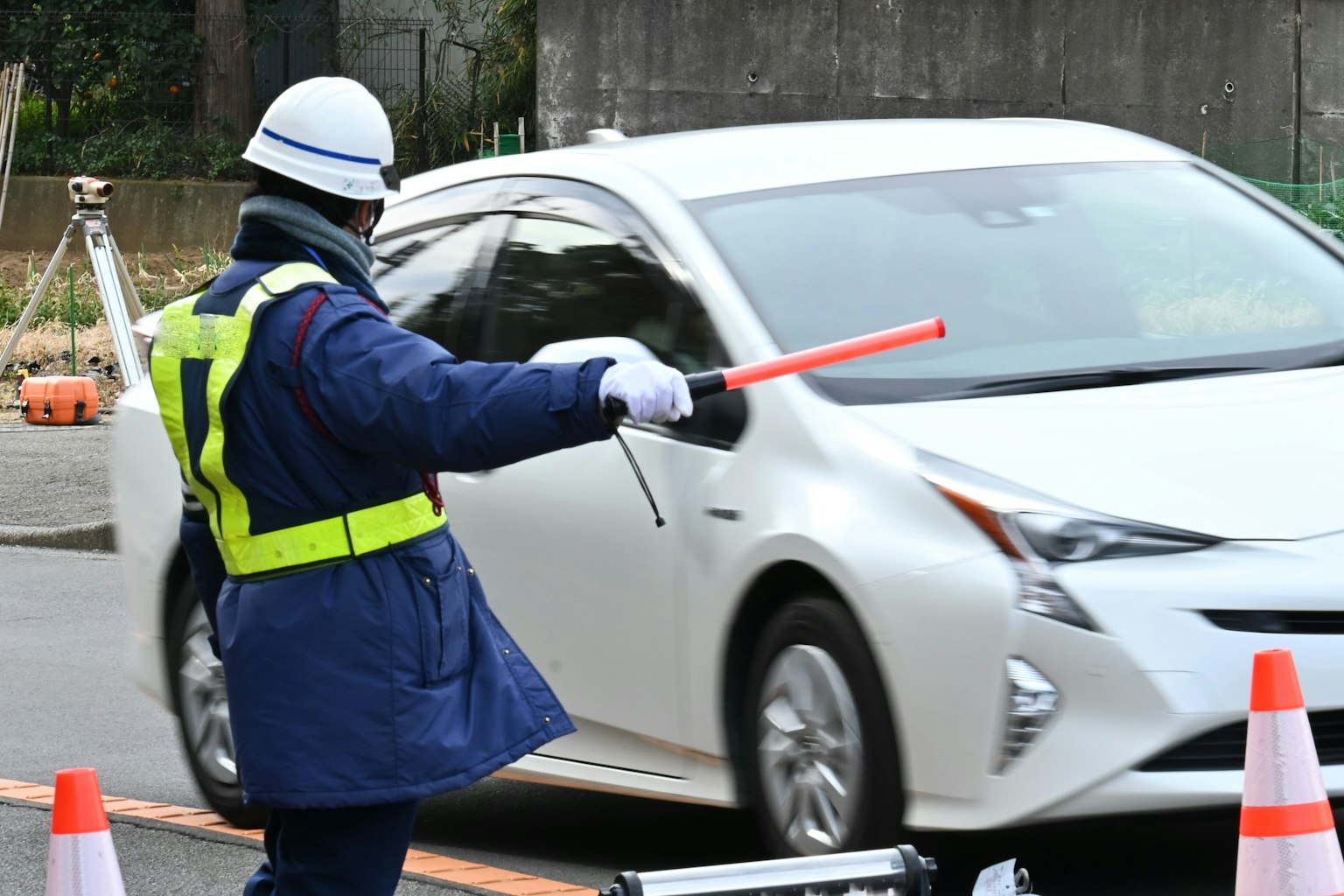 交通警察用红色指挥棒指挥白色汽车