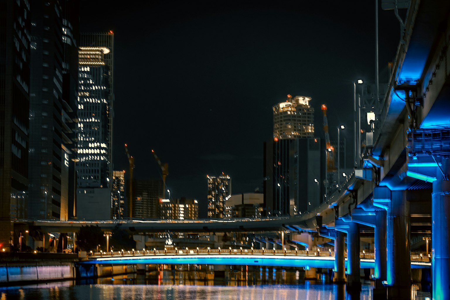Nachtstadtansicht mit beleuchtetem blauen Brücke