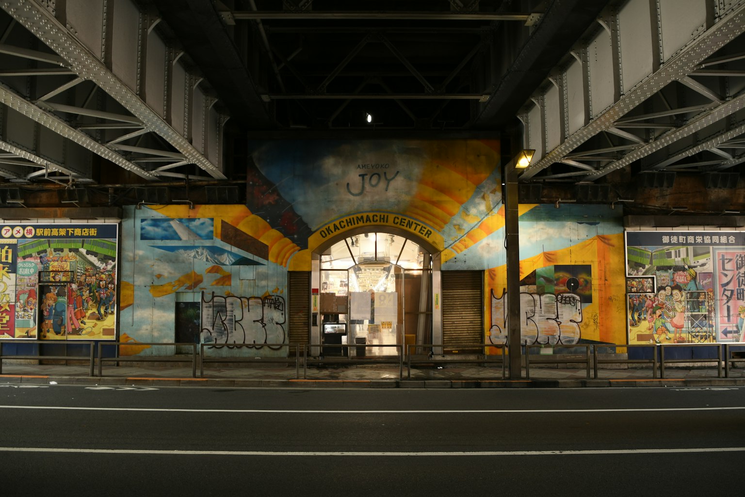 Bunte Wandmalereien schmücken einen Bogen-Eingang in einem Unterführungsbereich