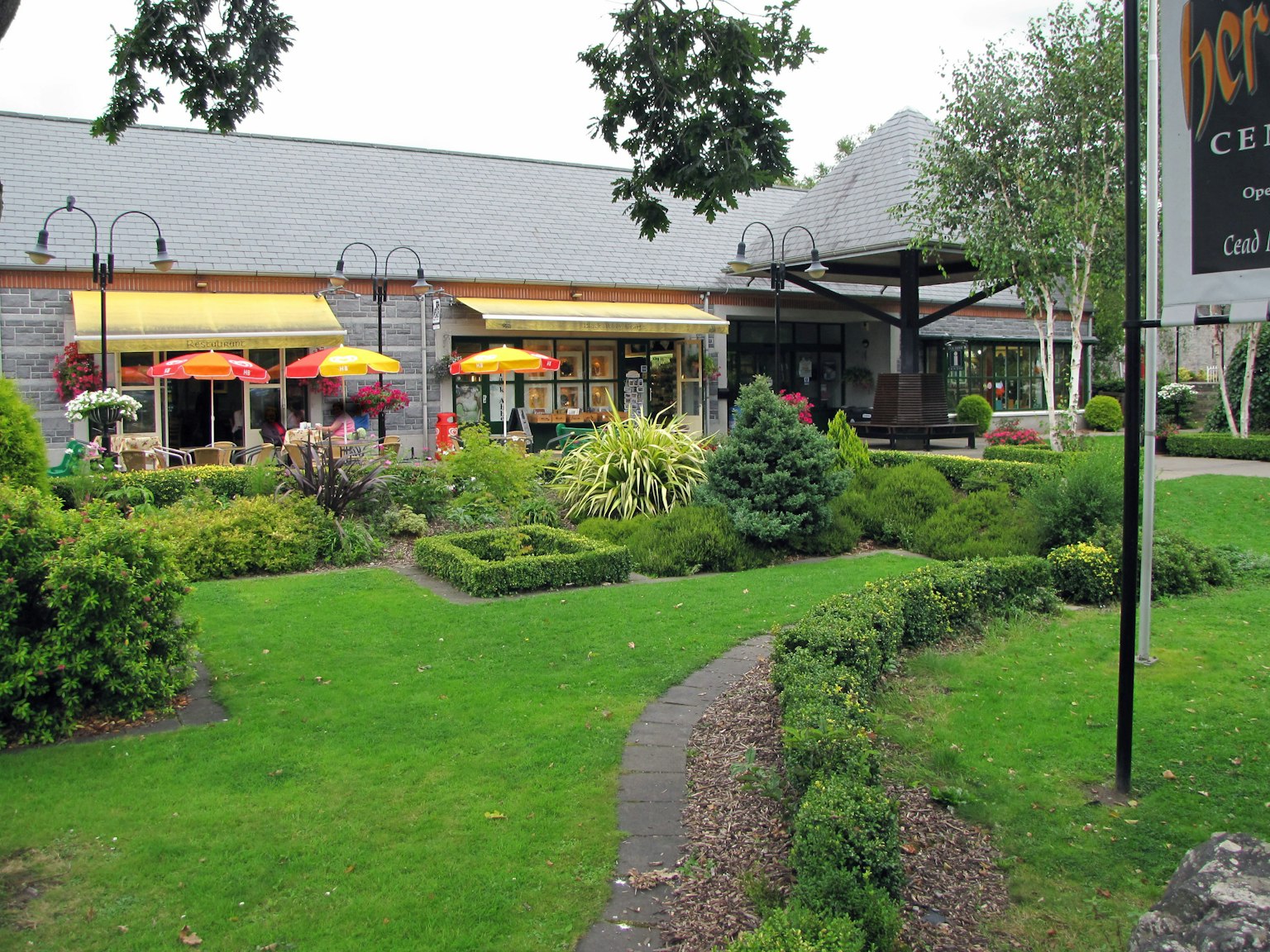 Extérieur d'un café entouré de verdure luxuriante parasols colorés et fleurs