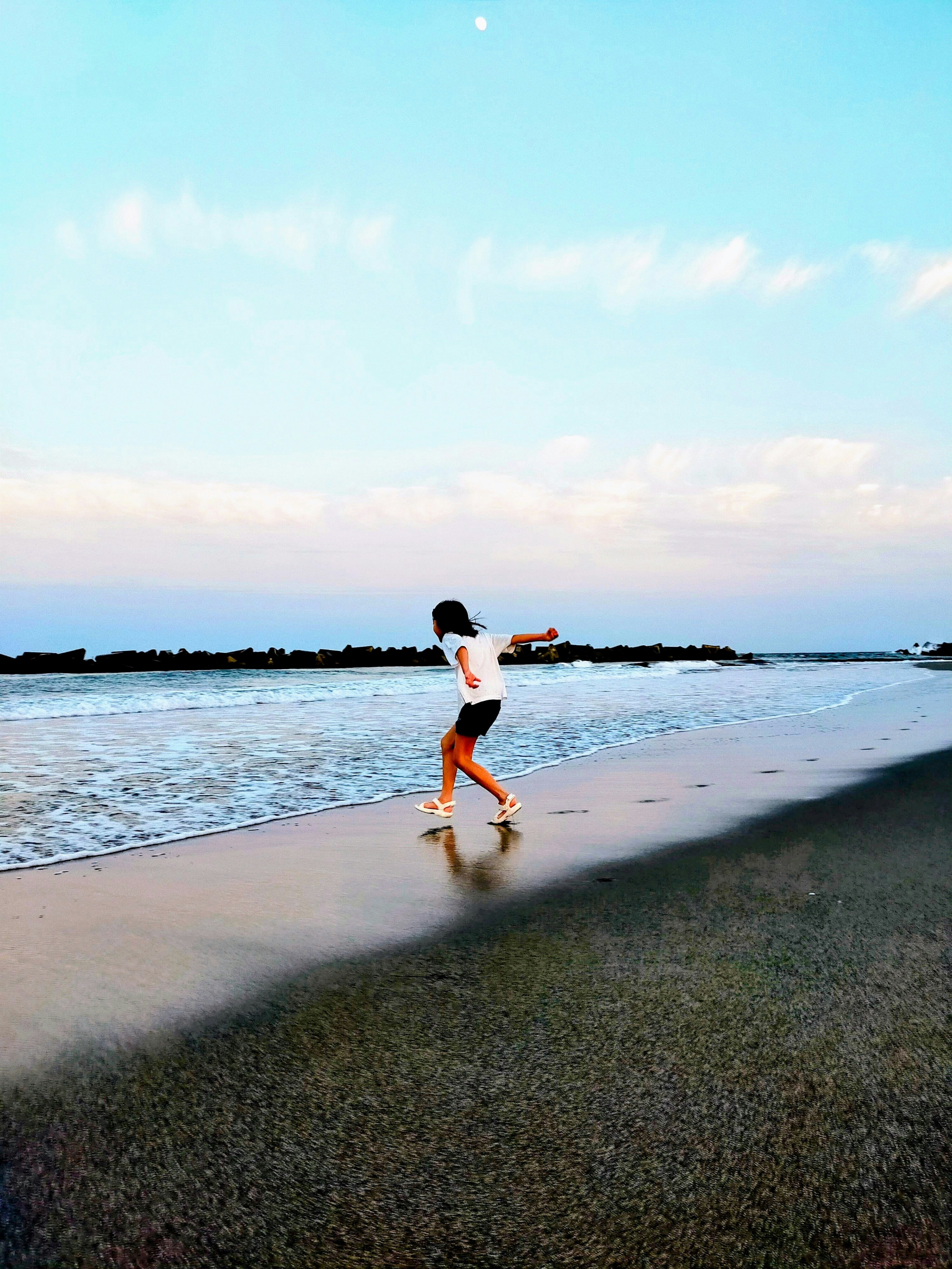 在宫城县仙台市的深沼海水浴场跳入大海的人与海浪拍打的沙滩