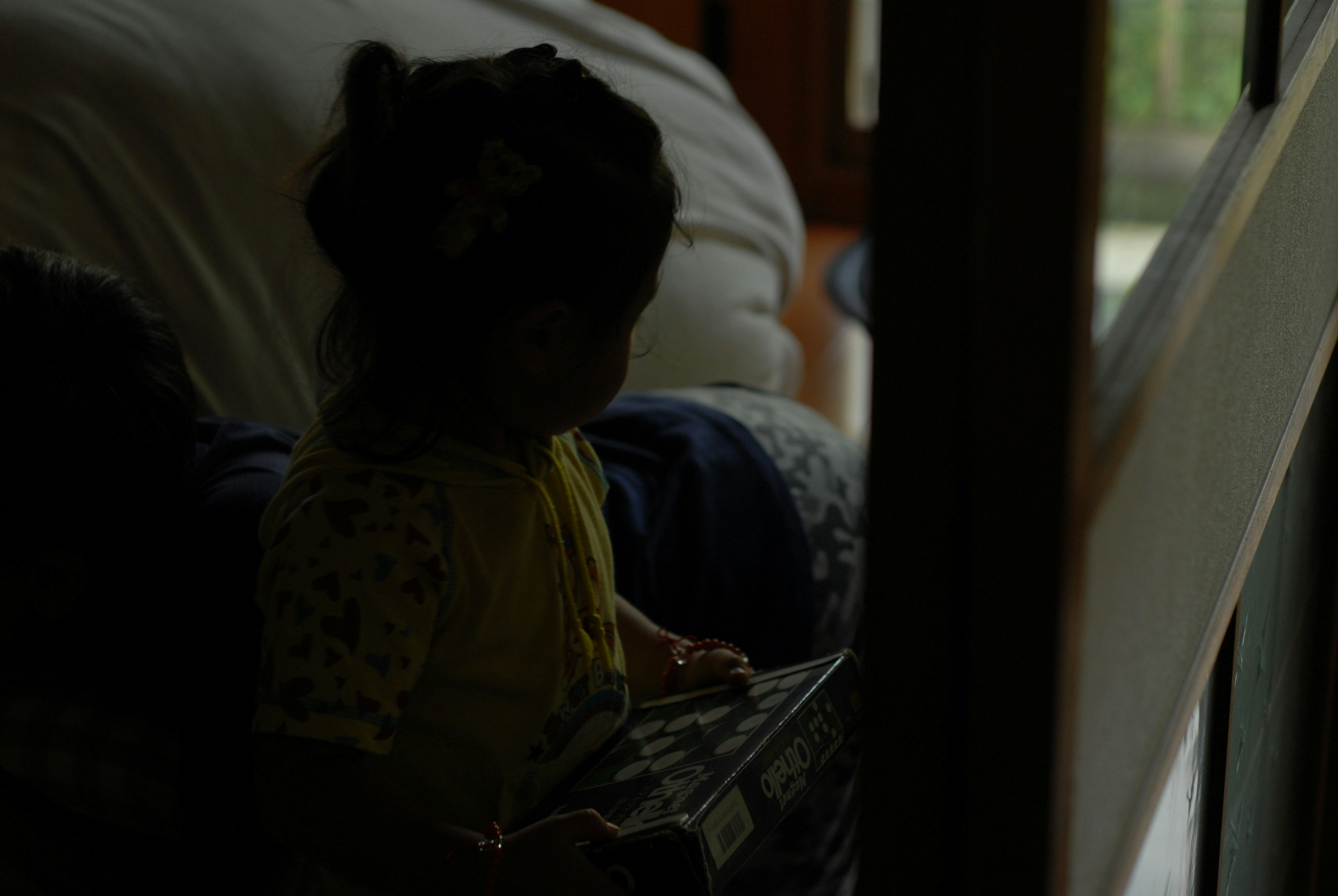 child reading a picture book by the window