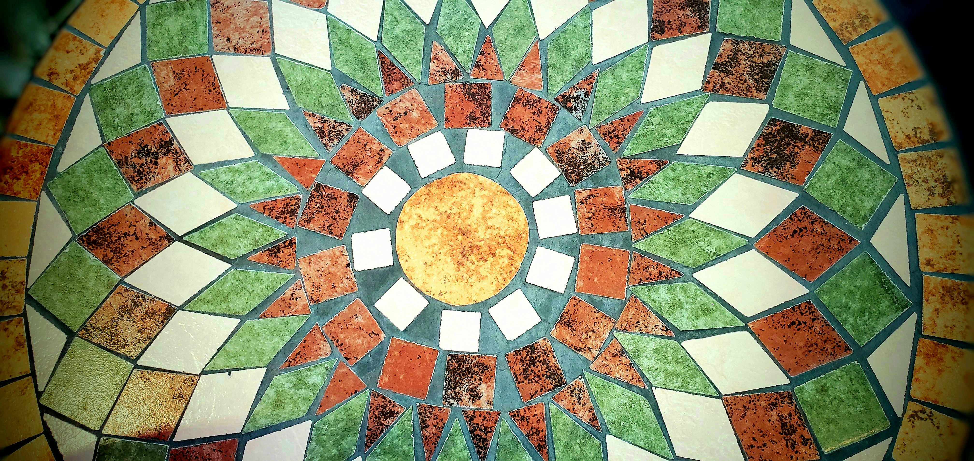 Plafond en mosaïque de carreaux géométriques avec un motif de soleil central