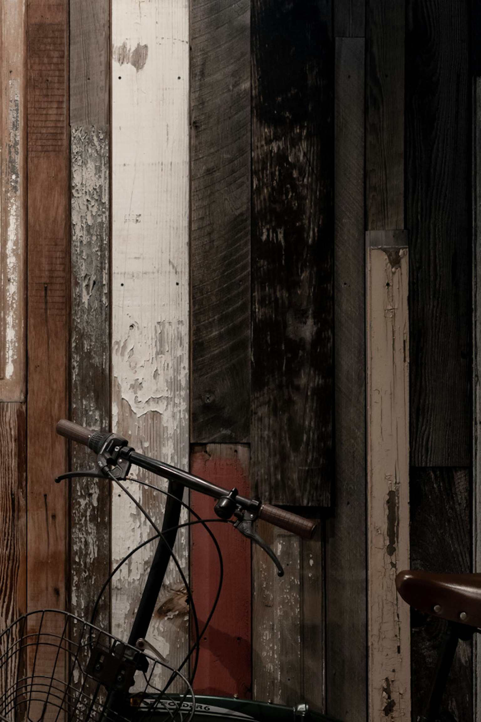 Image présentant un mur en bois ancien avec une partie de vélo