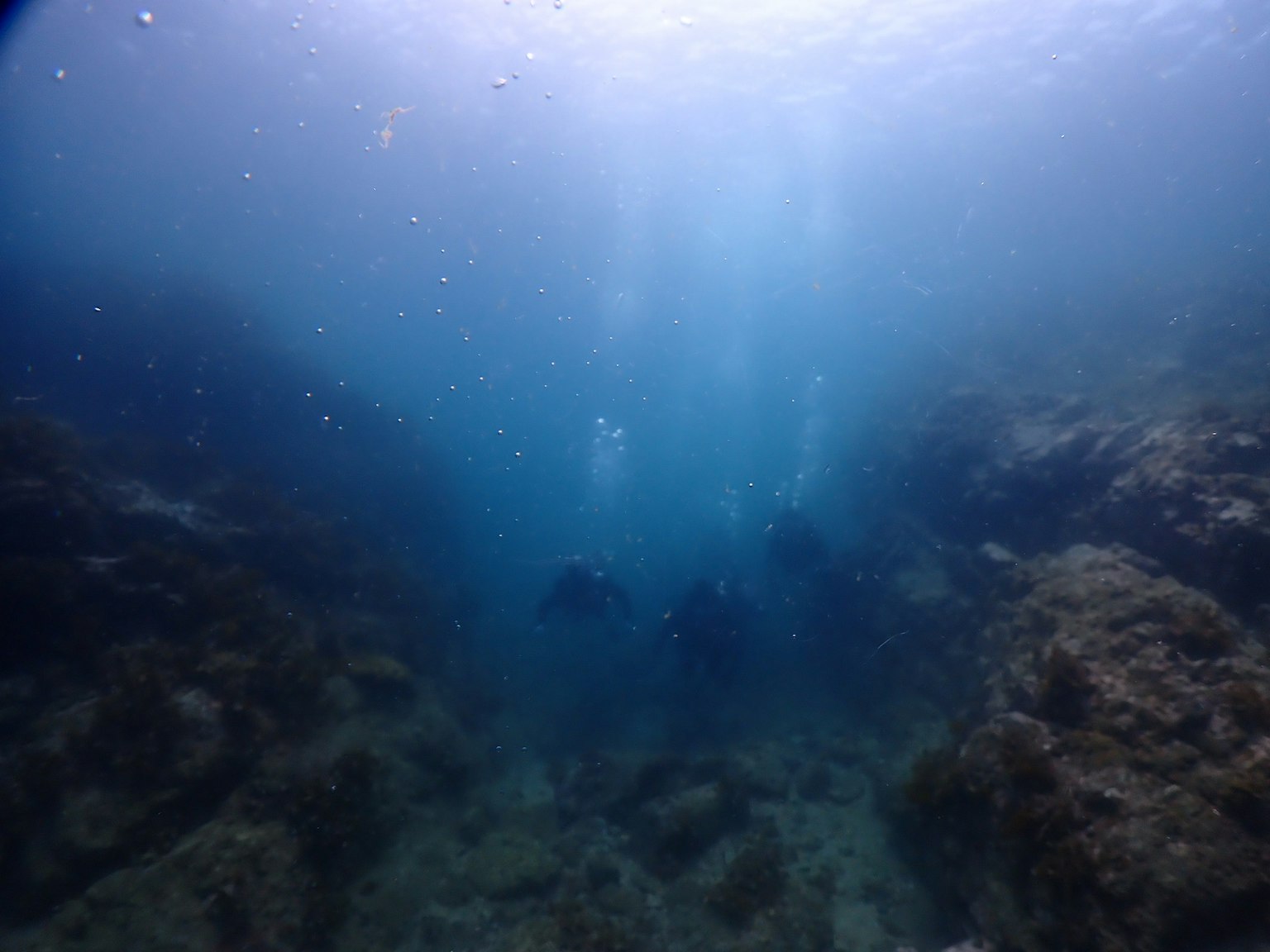 Pemandangan bawah air biru dalam dengan sinar cahaya dan gelembung yang terlihat