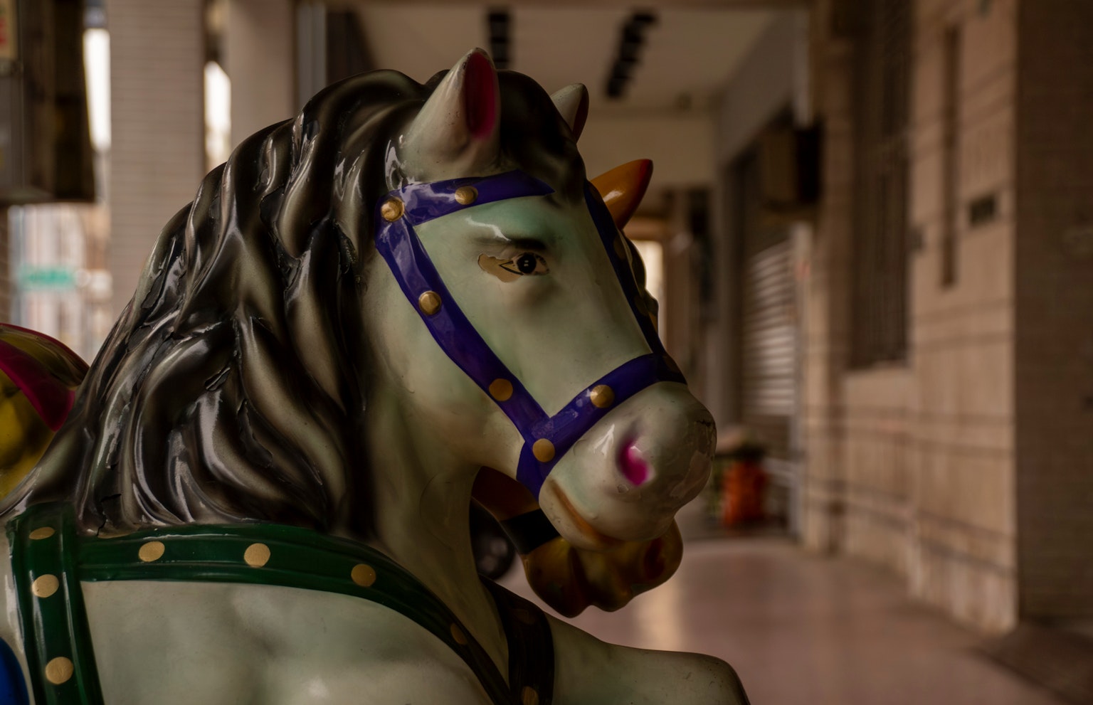 Close-up kepala kuda carousel dengan dekorasi berwarna-warni