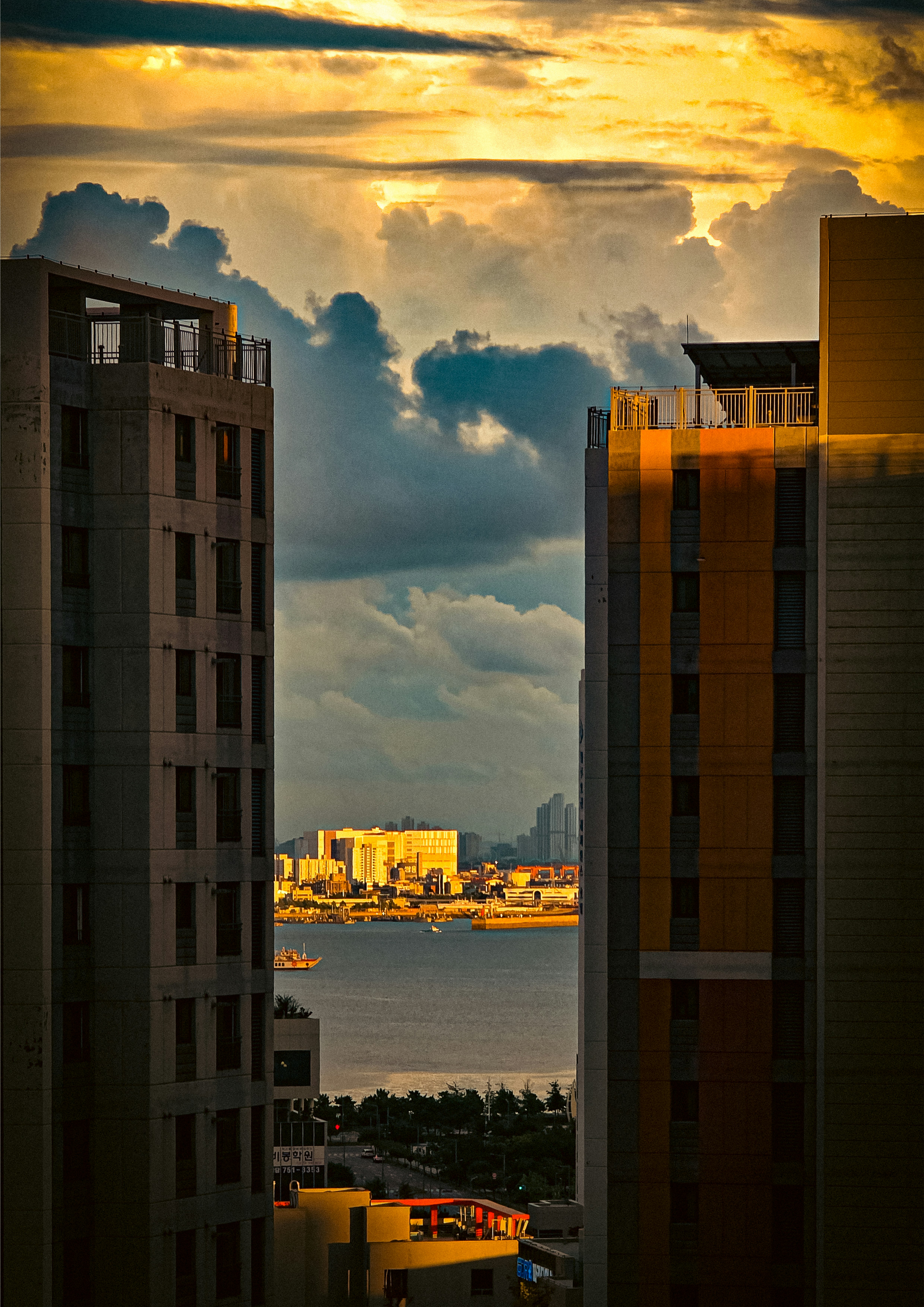 川沿いの高層住宅と夕焼けの雲の風景