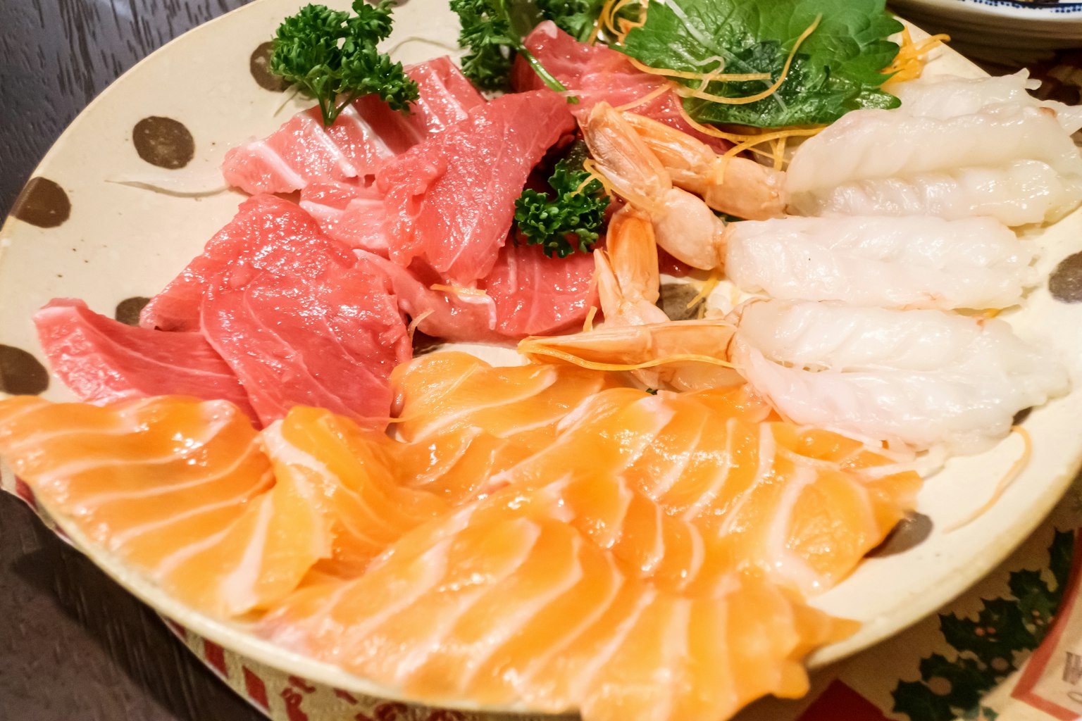 Plateau de sashimi vibrant avec divers poissons colorés disposés sur une assiette