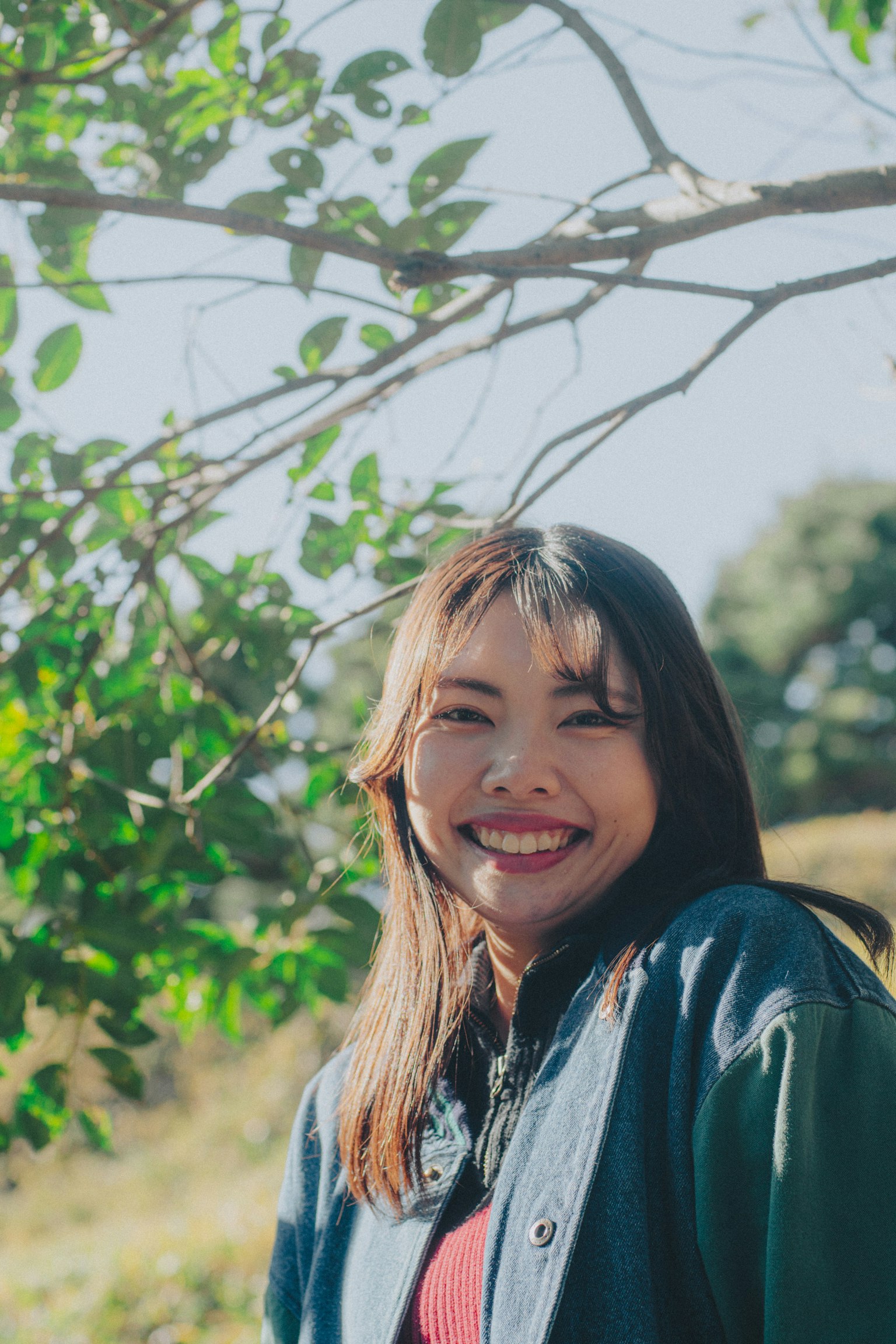 Portrait of a smiling woman in front of green leaves