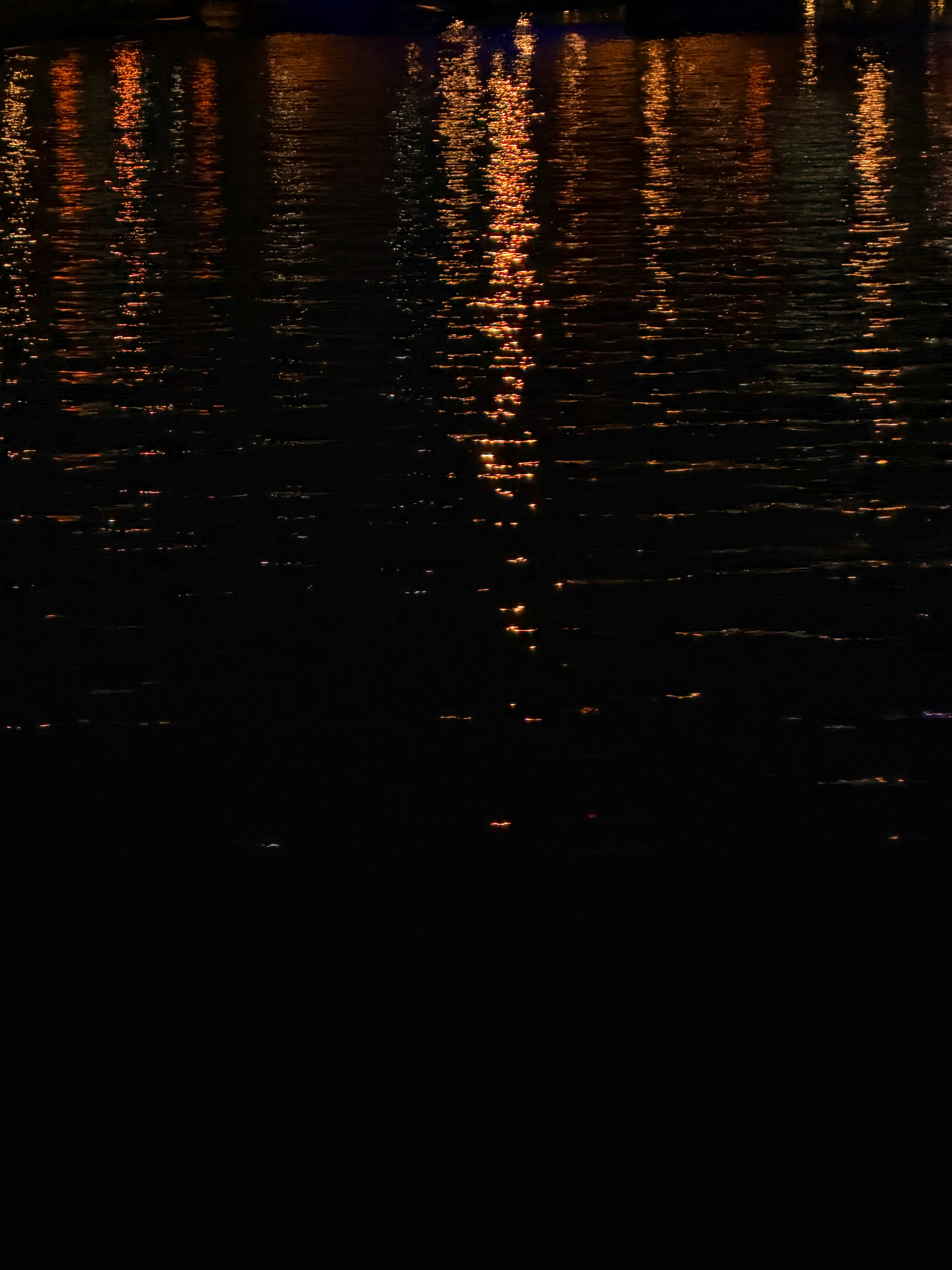 水面に映るオレンジ色の光の反射が美しい夜の風景