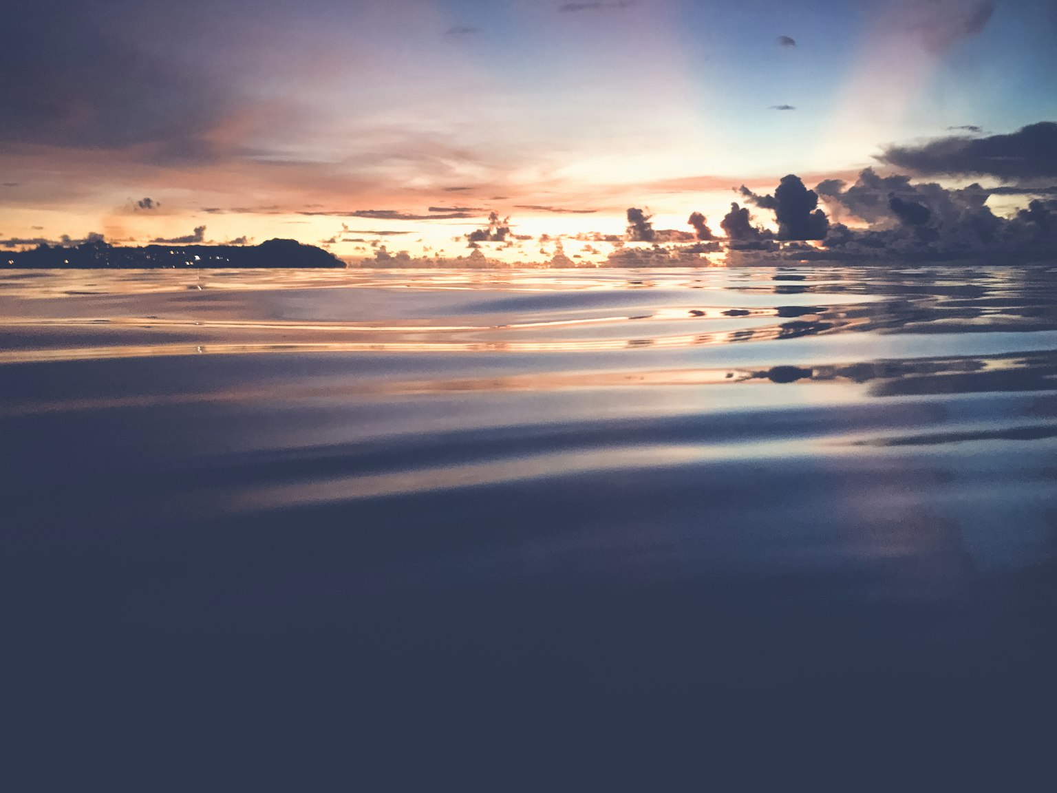 Superficie calma dell'oceano con un bellissimo tramonto