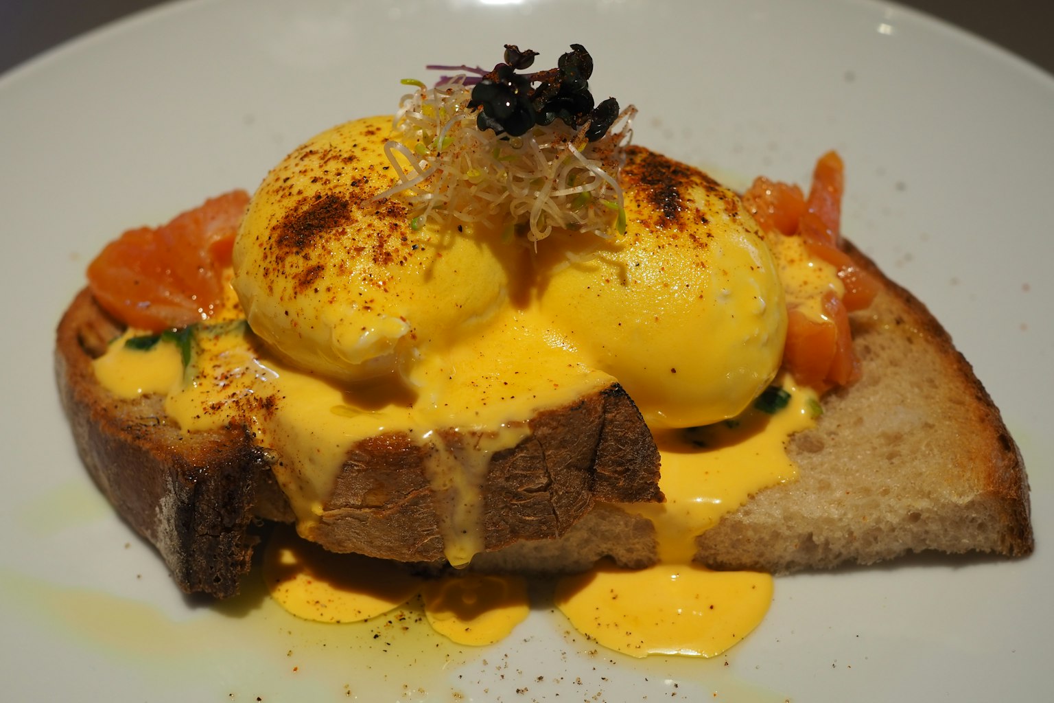 Toast con salmone affumicato e uova in camicia, guarnito con salsa olandese
