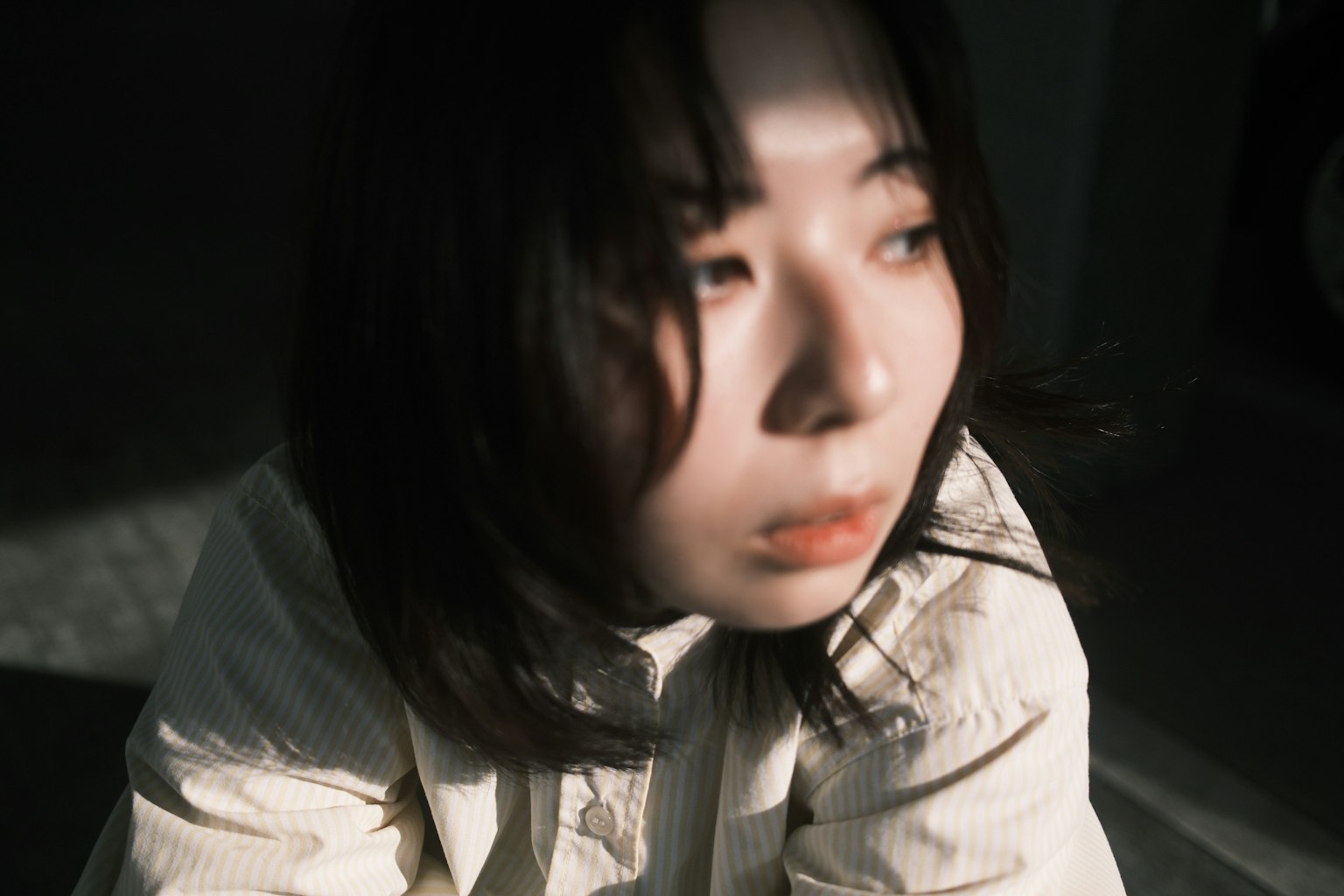 暗い背景の中で考え込む女性のポートレート