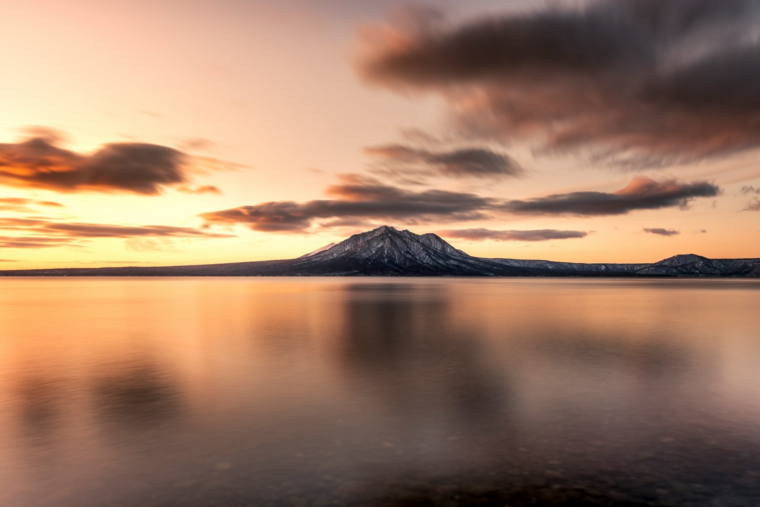 Ruhige Landschaft mit See und Berg mit reflektierenden Sonnenuntergangsfarben