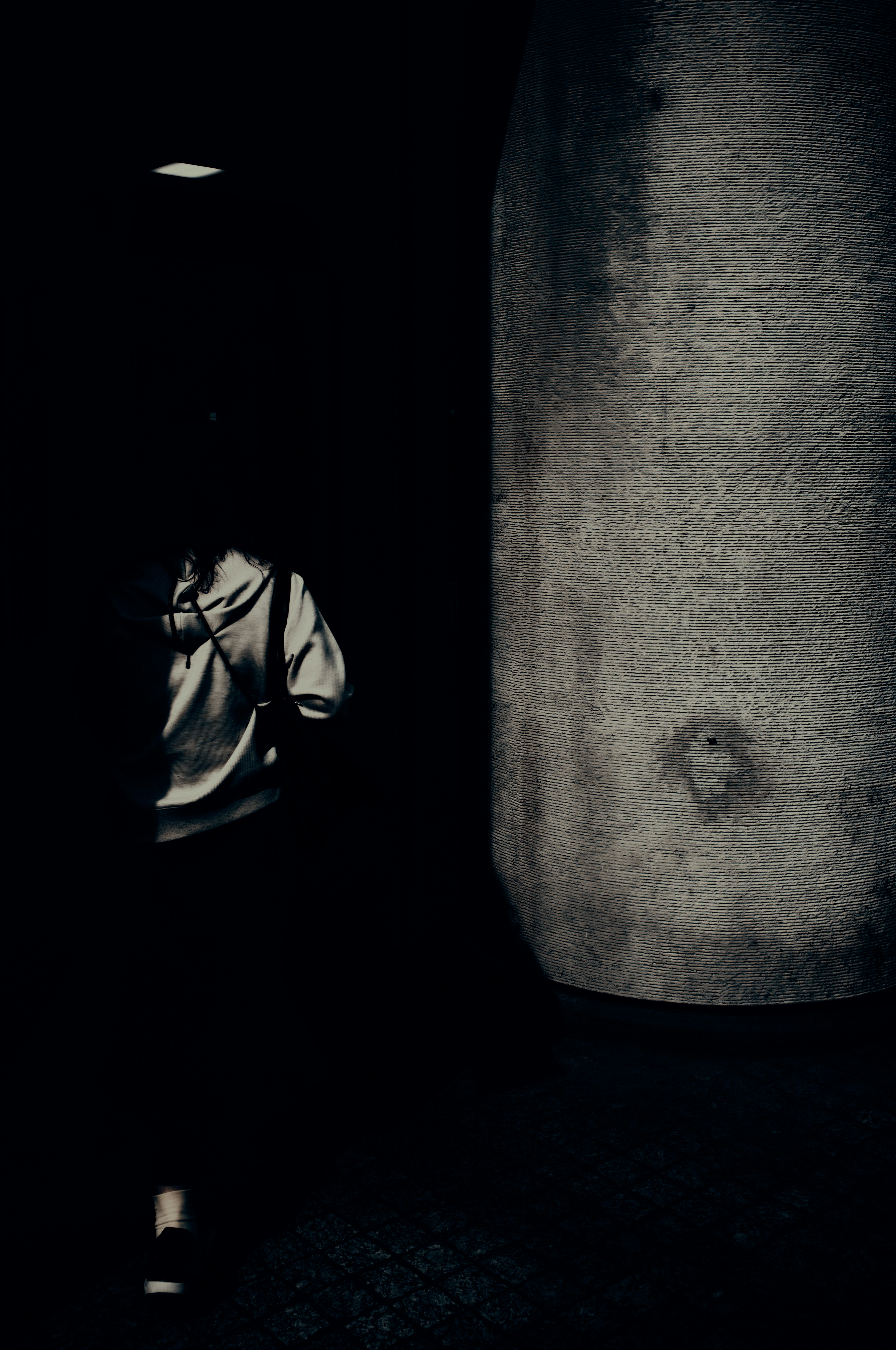 silhouette of a person cast on a dark alley wall