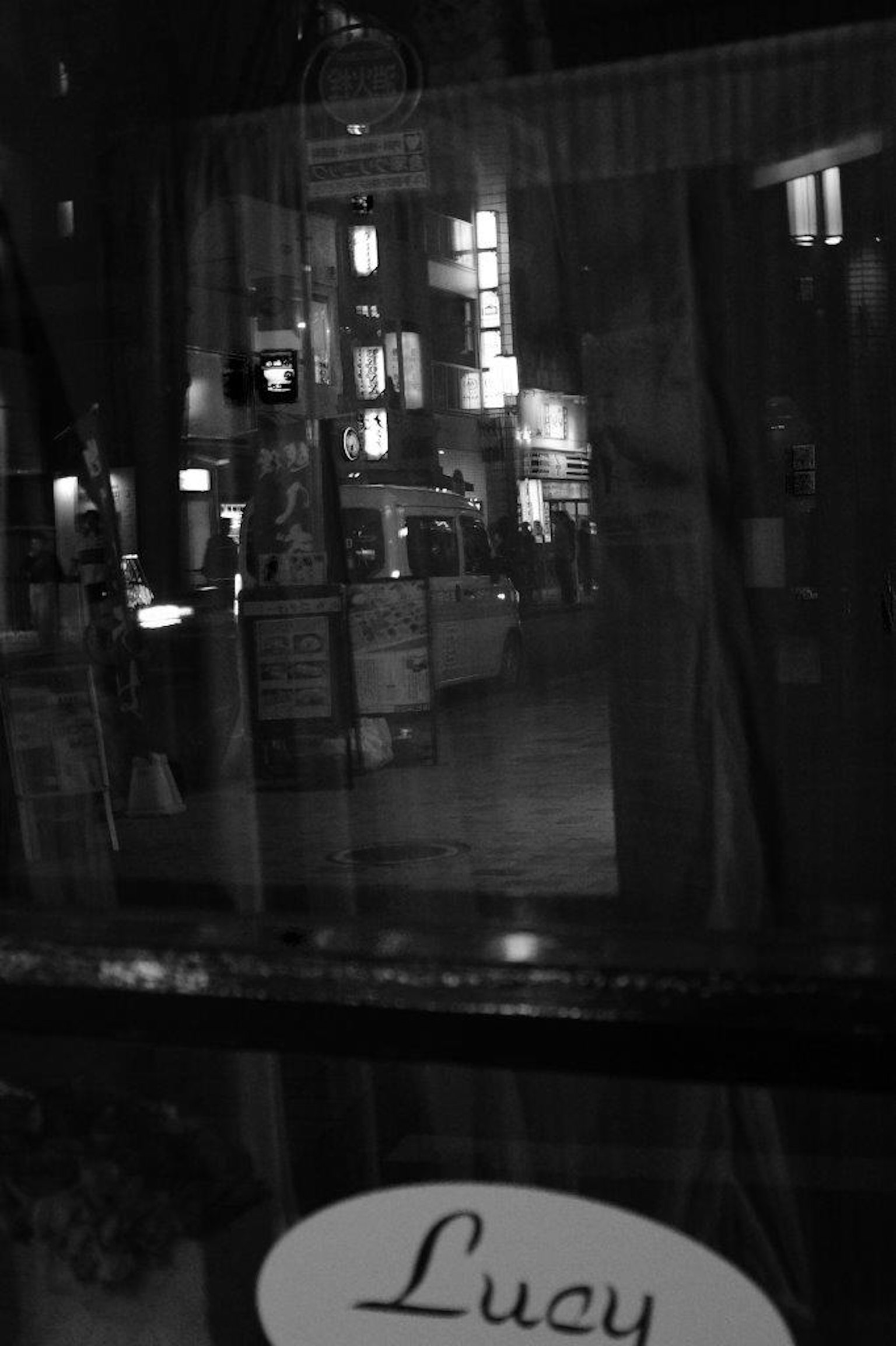 Schwarz-weiß Stadtansicht durch ein Fenster sichtbar Licht und Schatten Schild Lucy