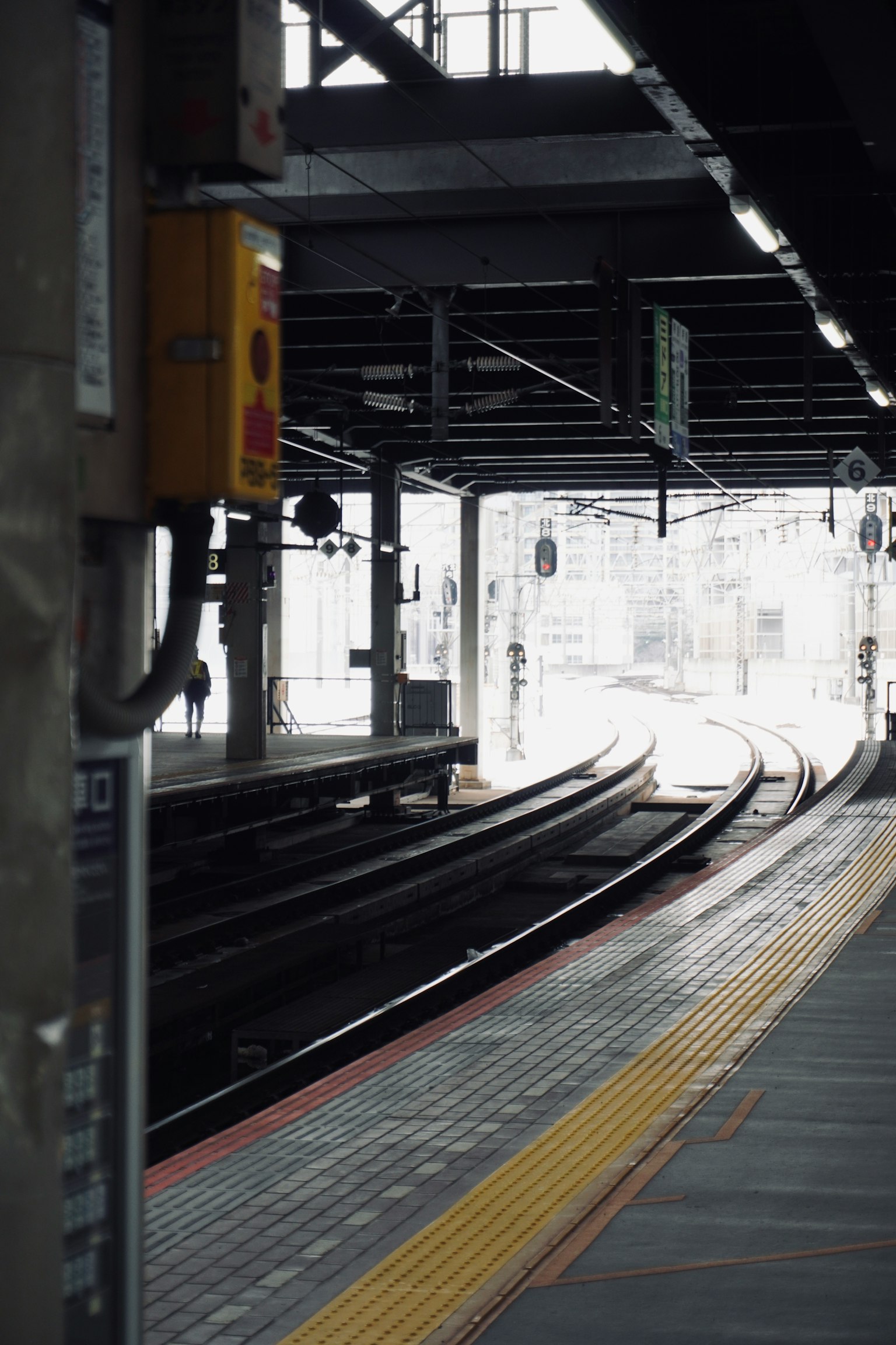 Vías curvas en una plataforma de tren con luces de señalización