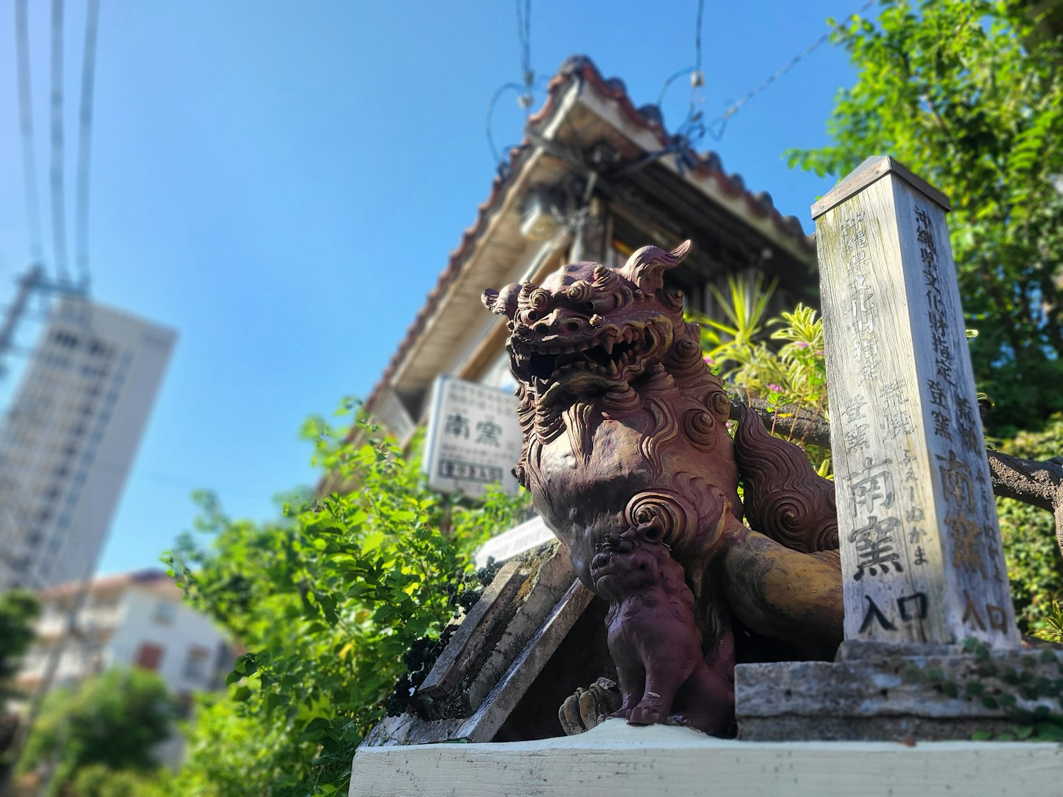 Statua di leone con una scultura di cucciolo davanti a un vecchio edificio