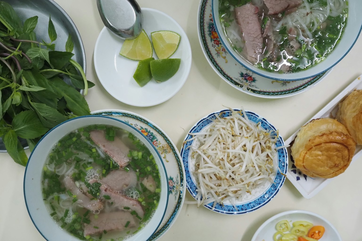 ก๋วยเตี๋ยวเวียดนามเสิร์ฟพร้อมมะนาว สมุนไพร และข้างเคียง