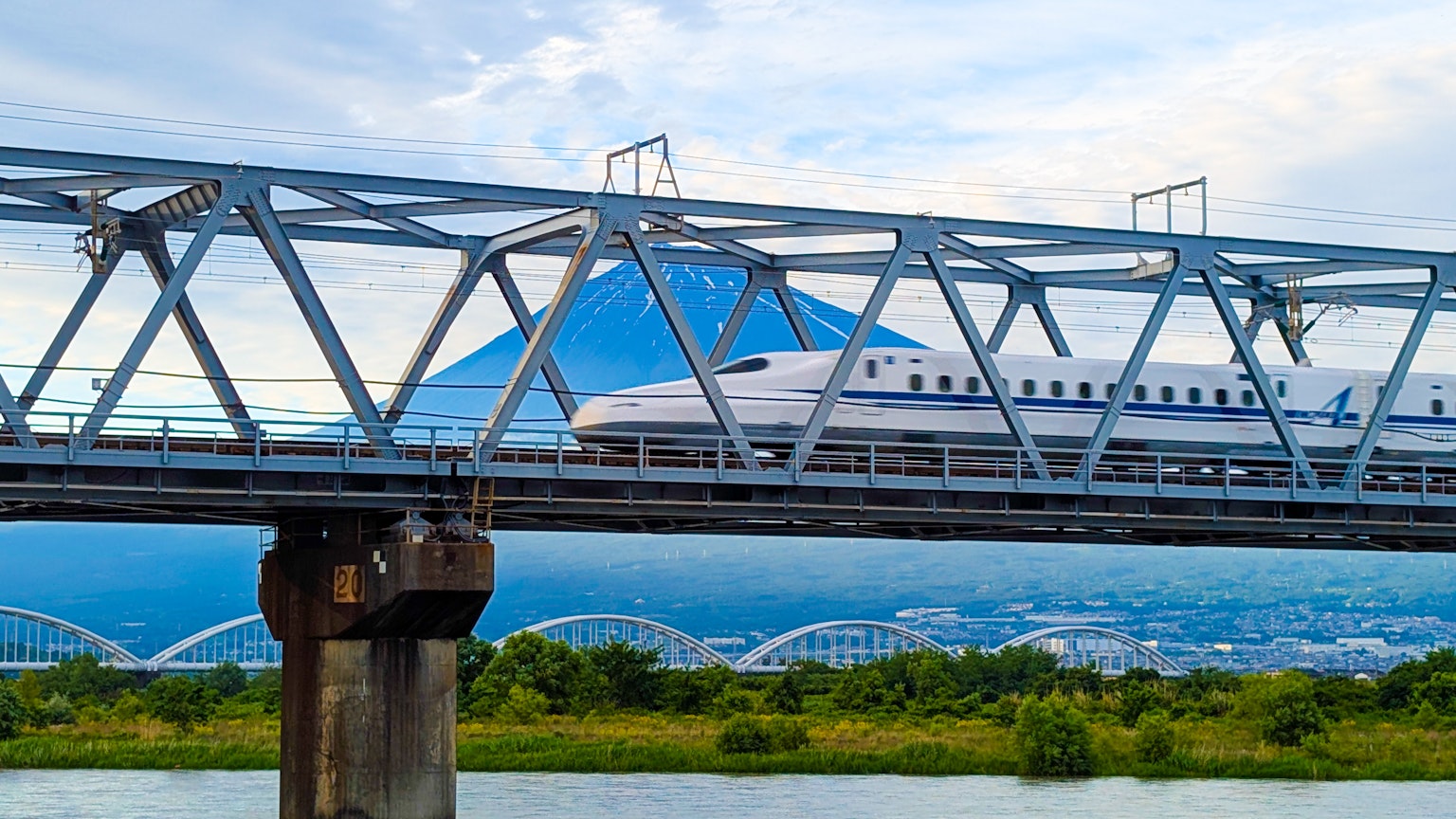 Train Shinkansen traversant un pont avec le mont Fuji en arrière-plan