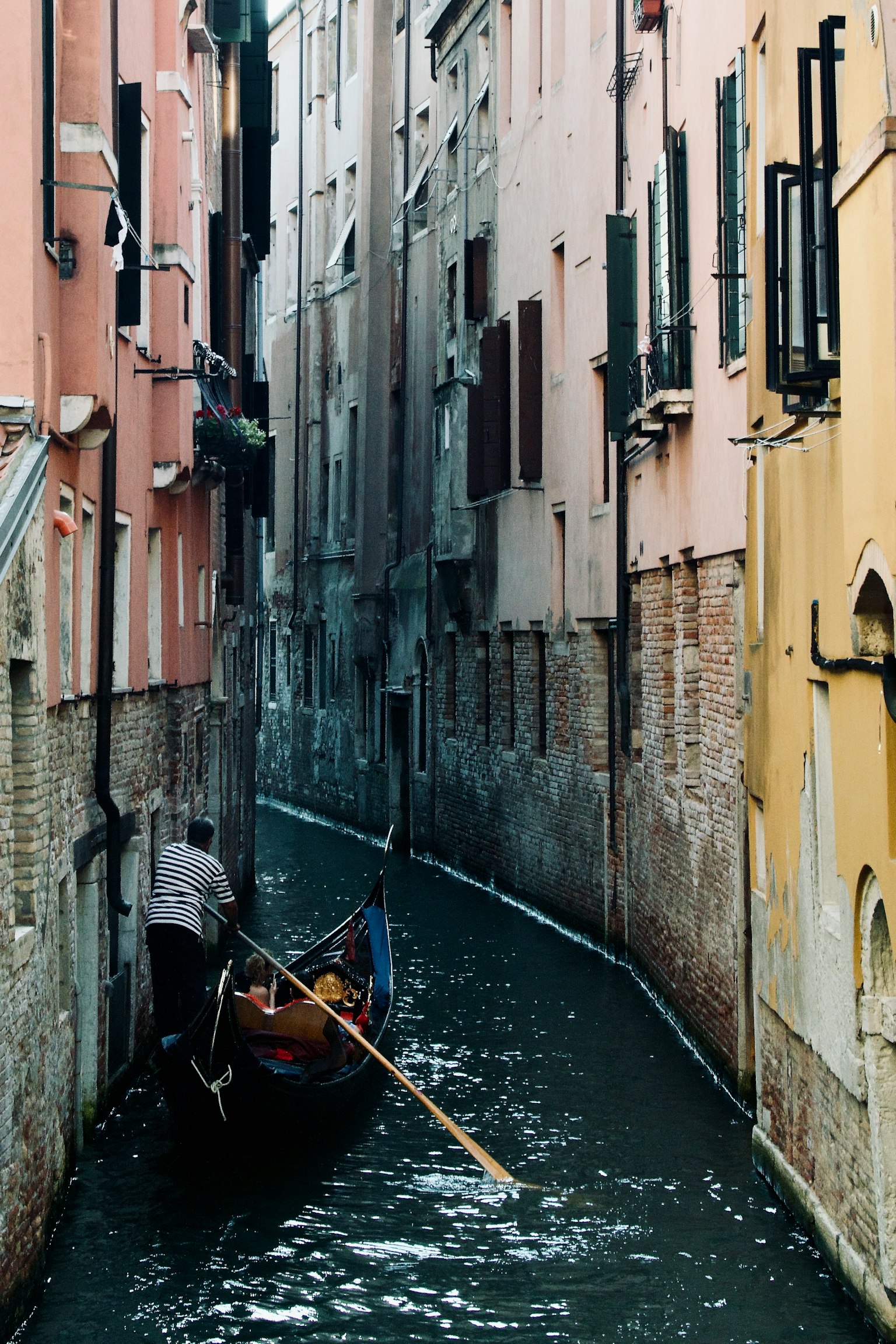 Gondola di chuyển trong một kênh hẹp với những tòa nhà nhiều màu sắc