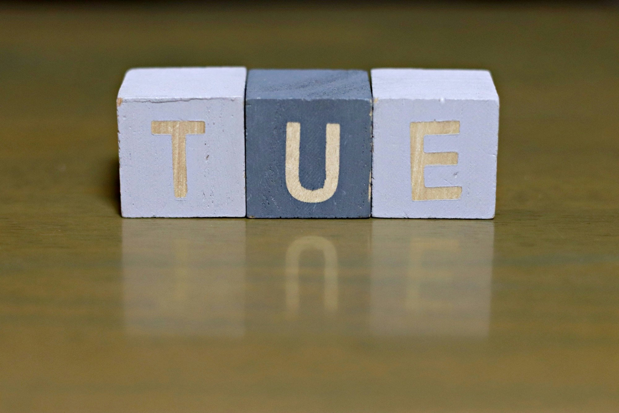 blocs en bois formant “TUE”