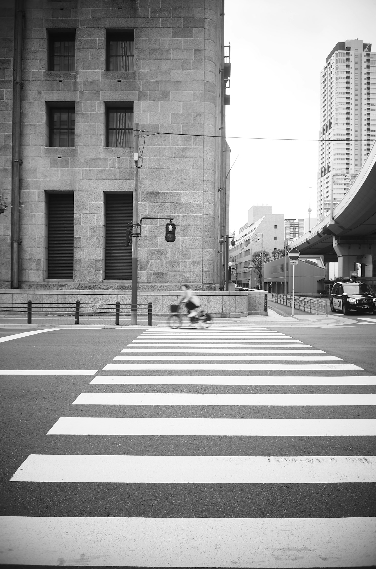 Paso de peatones en blanco y negro con un edificio moderno de fondo